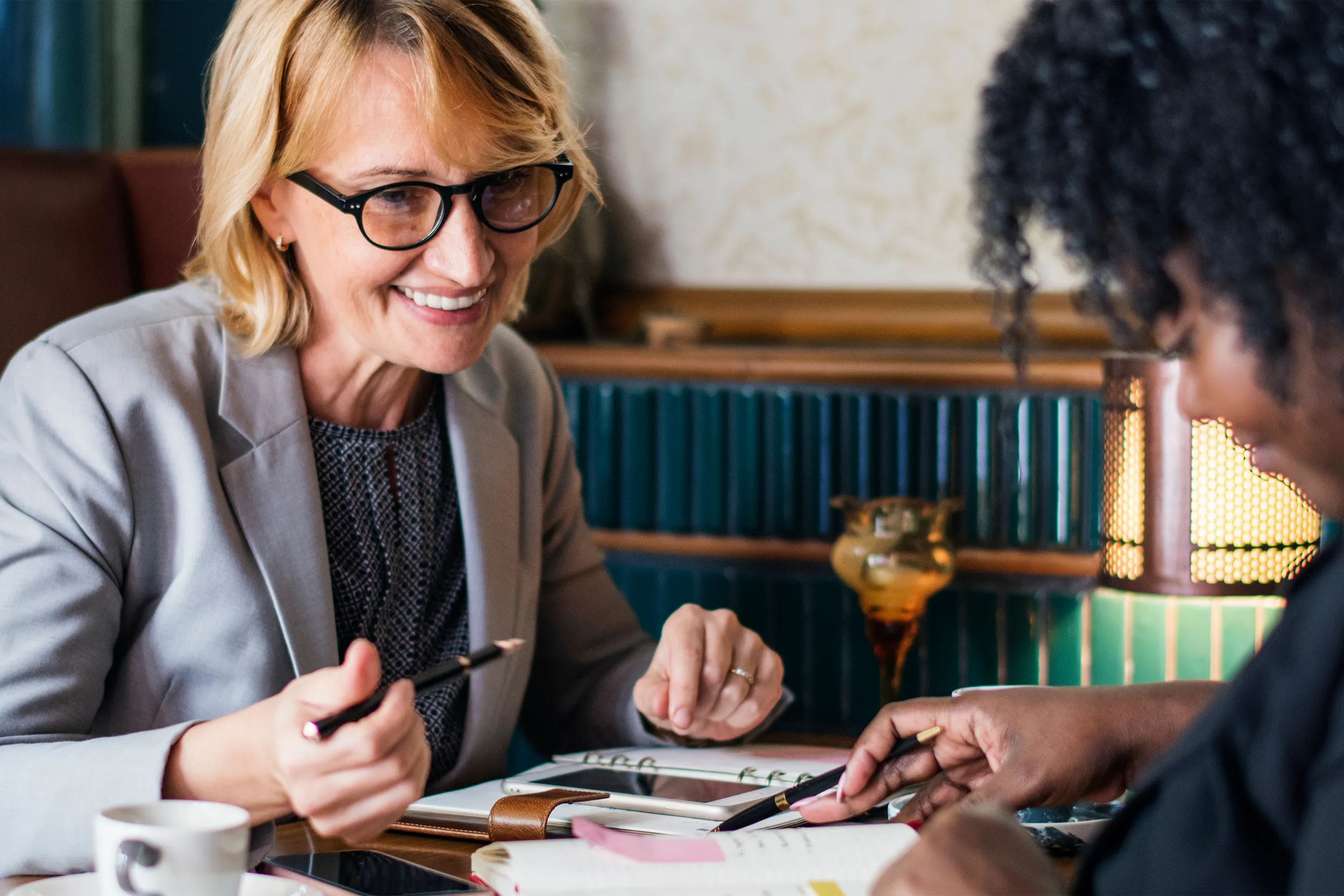 2 women talking together and going over business paperwork