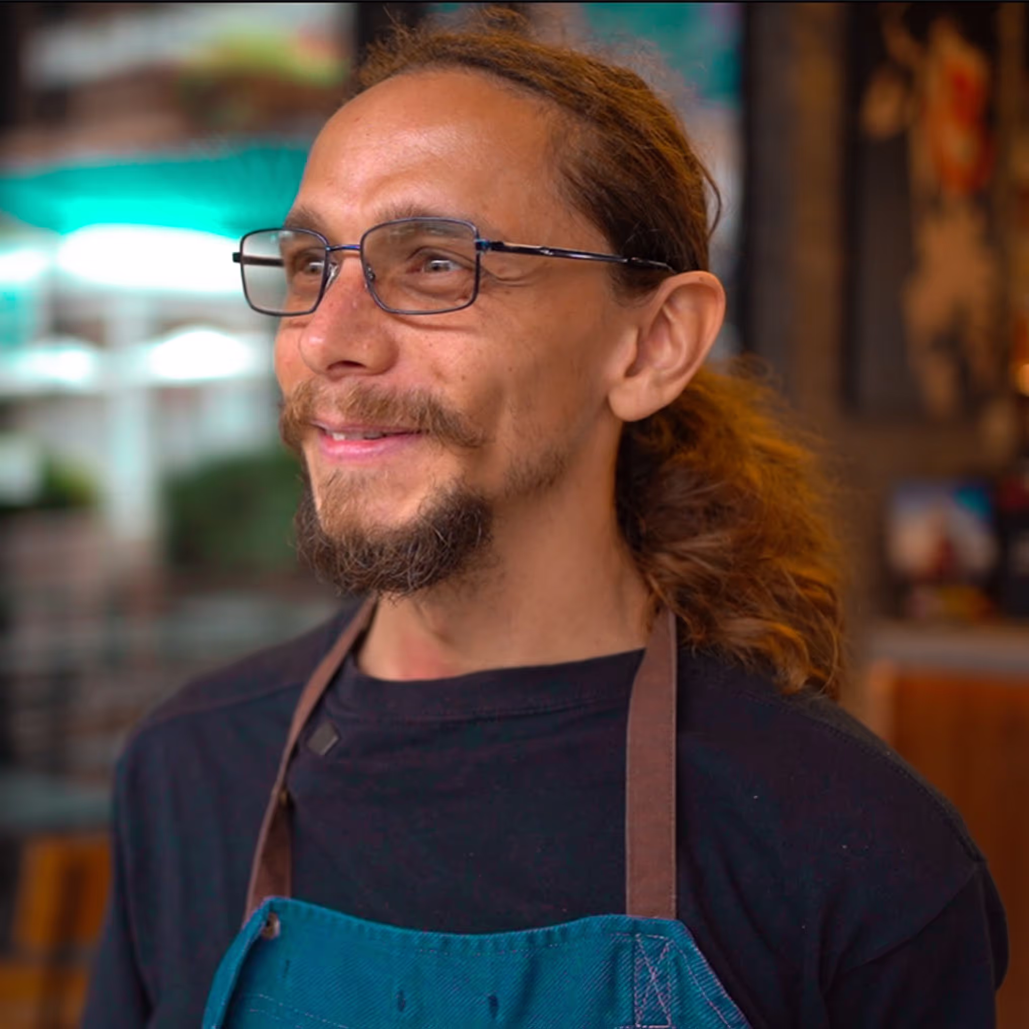 Man with glasses wearing apron 