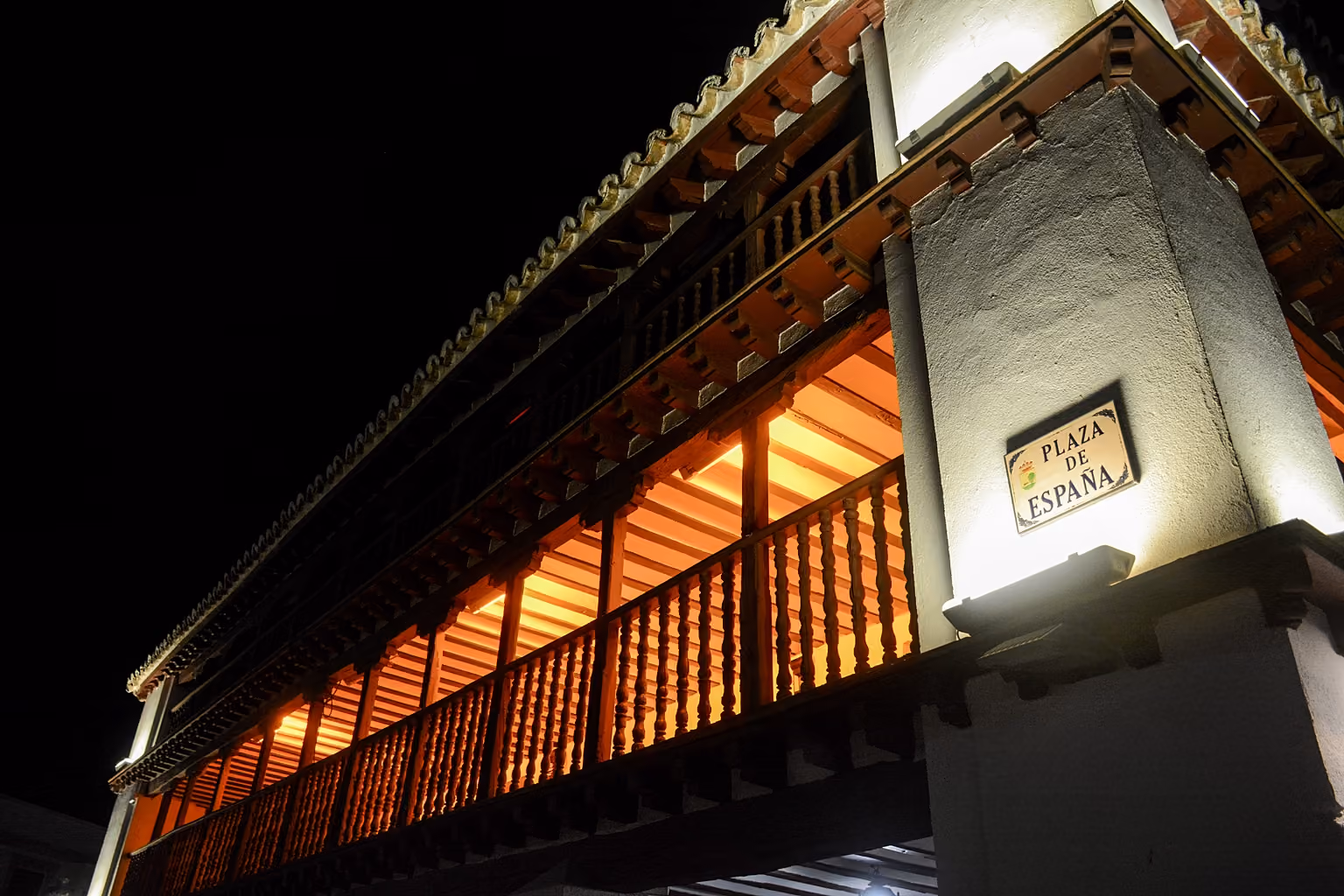 Fachada de la Posada de los Portales con baja iluminación en la noche.