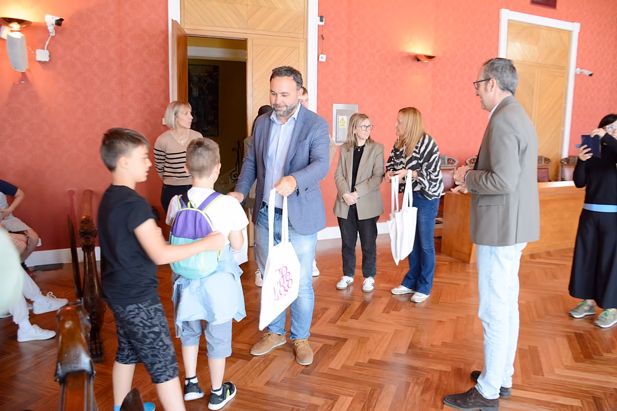 Imagen con el alcalde entrega obsequios a uno de los escolares italianos