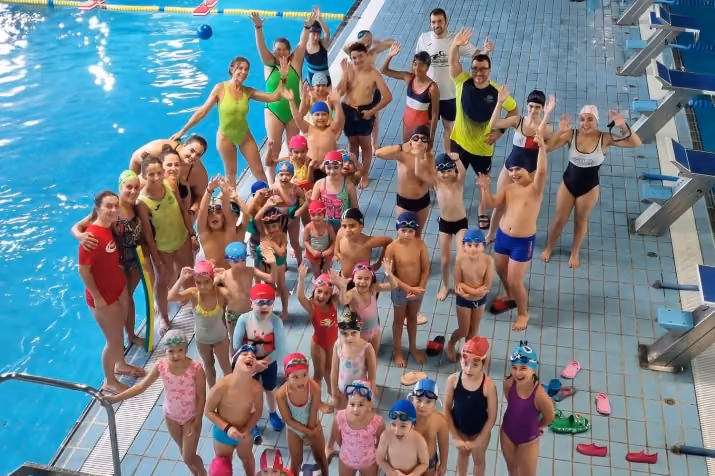 Imagen con un grupo de participantes con los monitores en la piscina