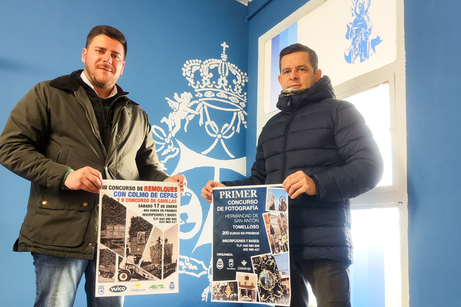 Manuel Marquina, a la izquerda de la imagen y Florentino Guijarro con el cartel de las fiestas de San Antón.