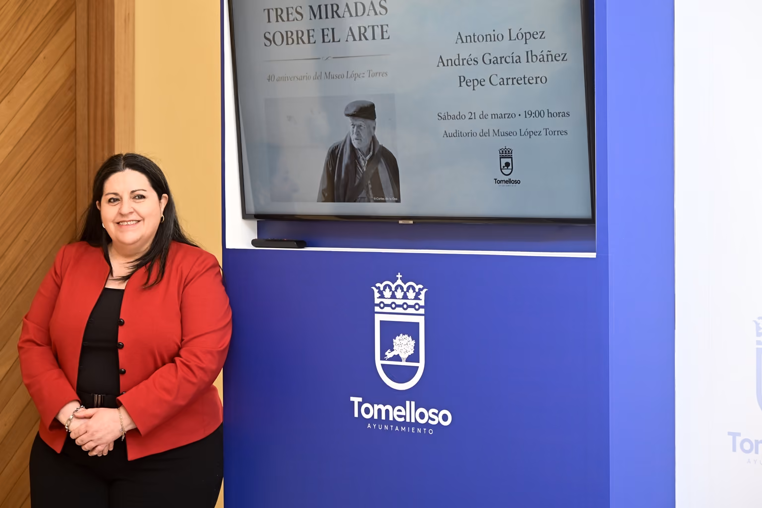 Inés Losa ante el cartel del encuentro Tres miradas sobre el arte