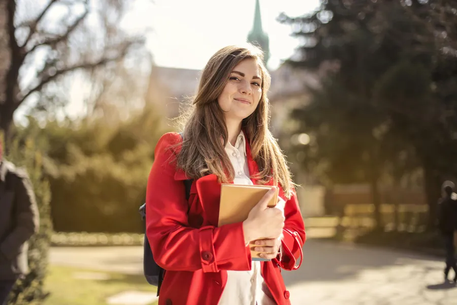 Student holding a notebook on campus