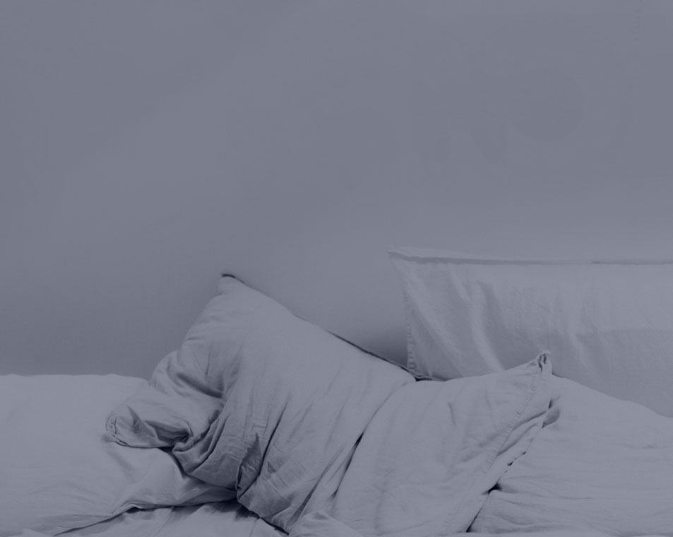 A pillow in a bed that represents relaxation and sleep.
