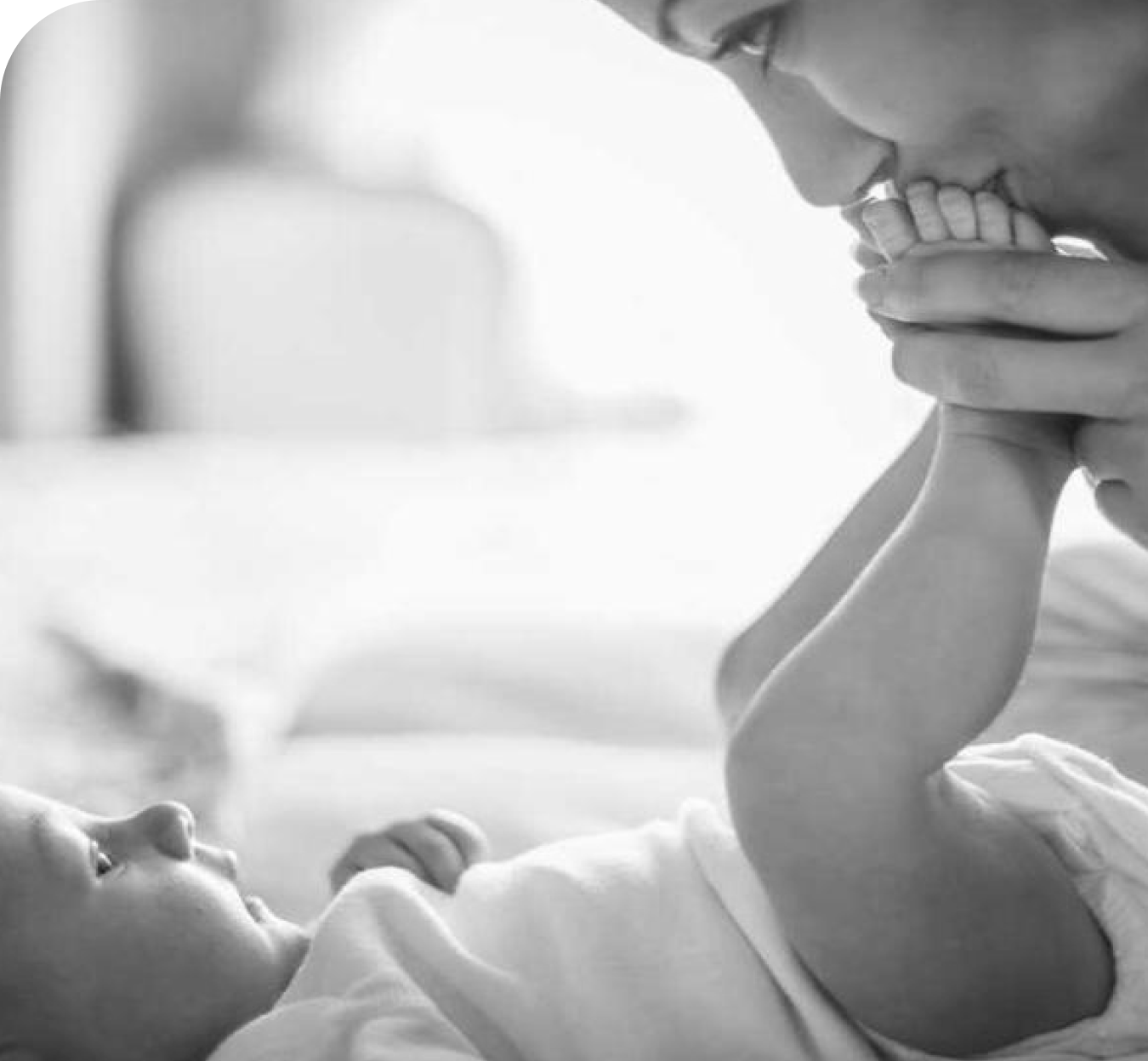 woman kissing her newborn baby