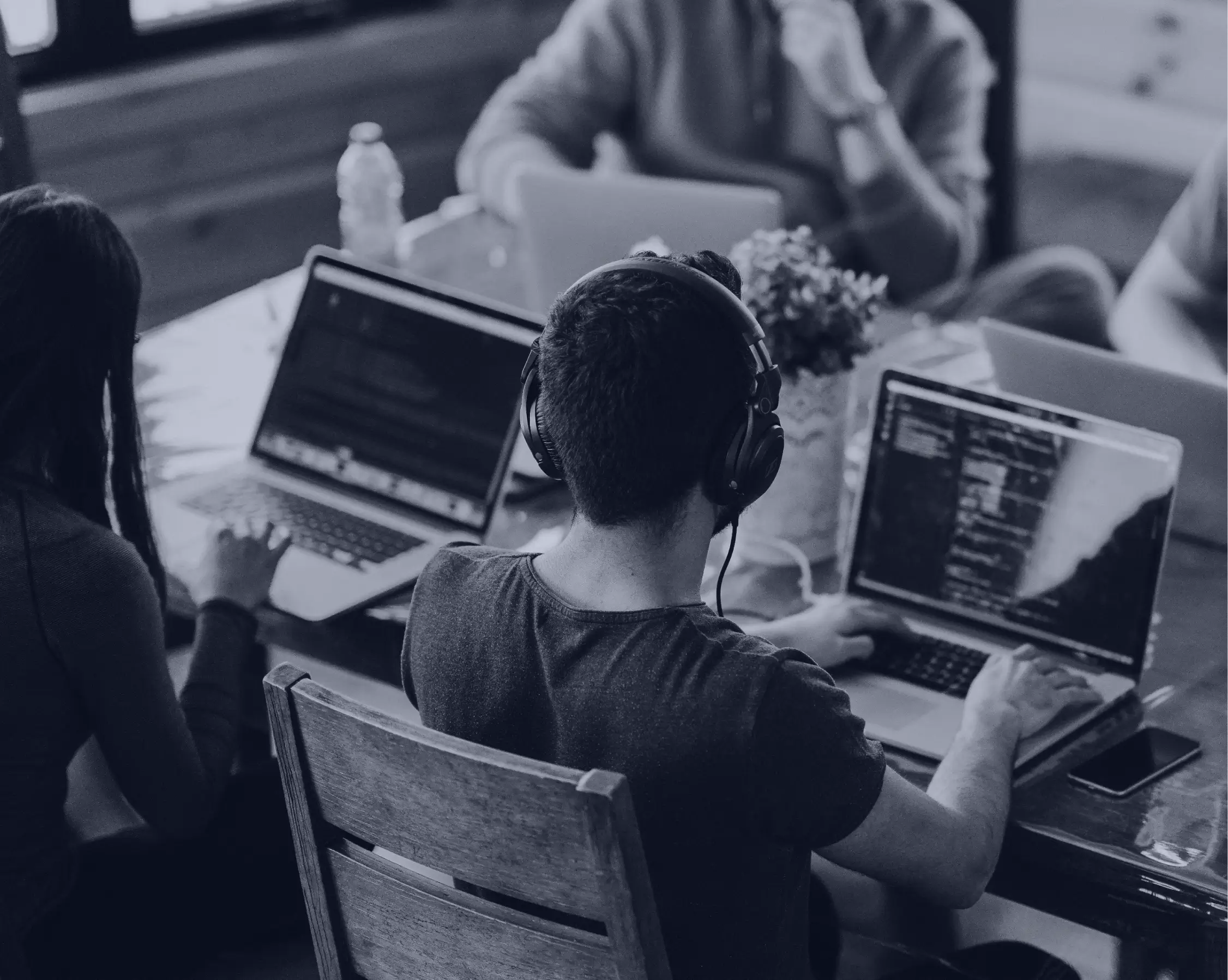 A front-end web developer listening to her colleague in a meeting.