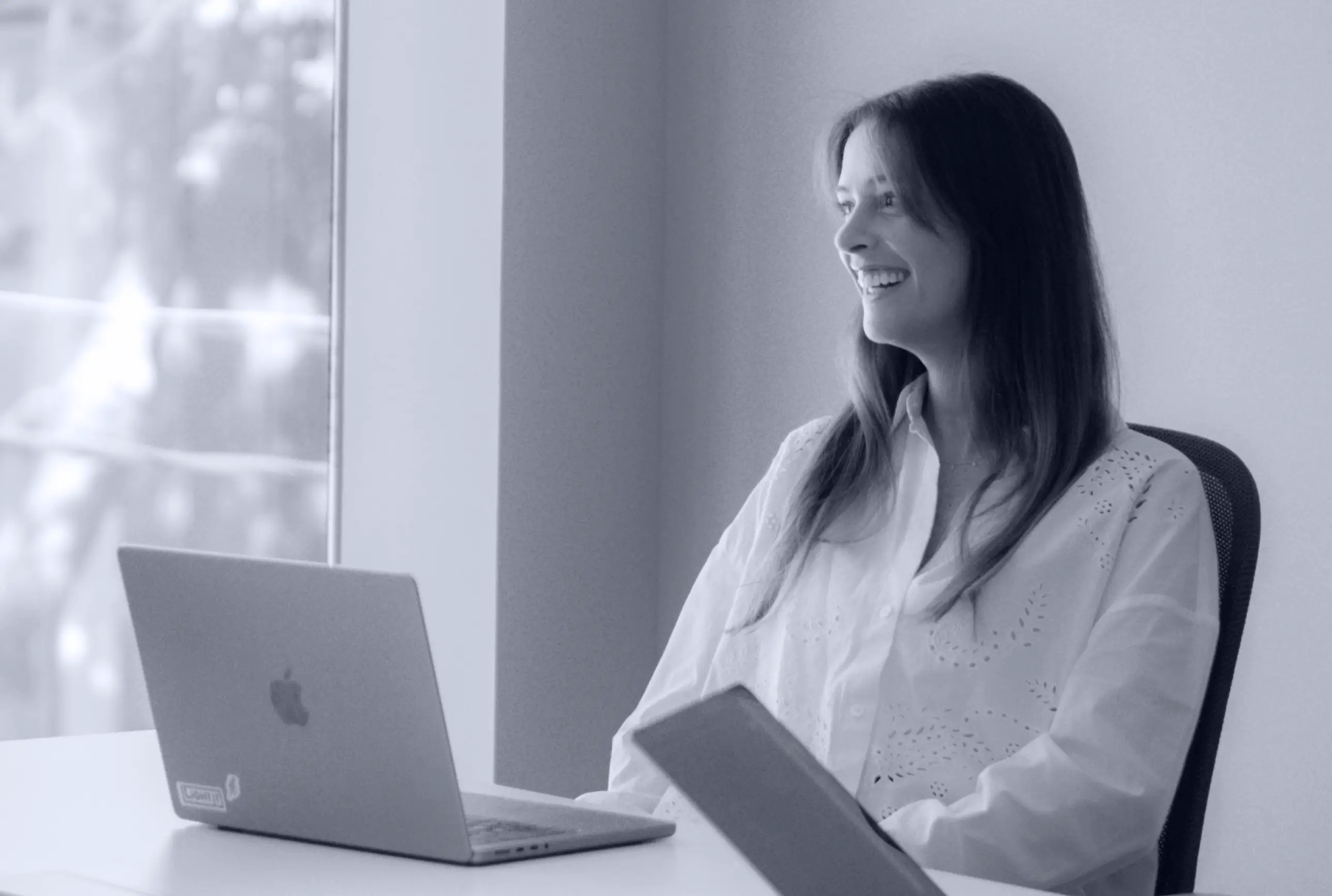 A female digital product manager working on her computer while sitting in an office.