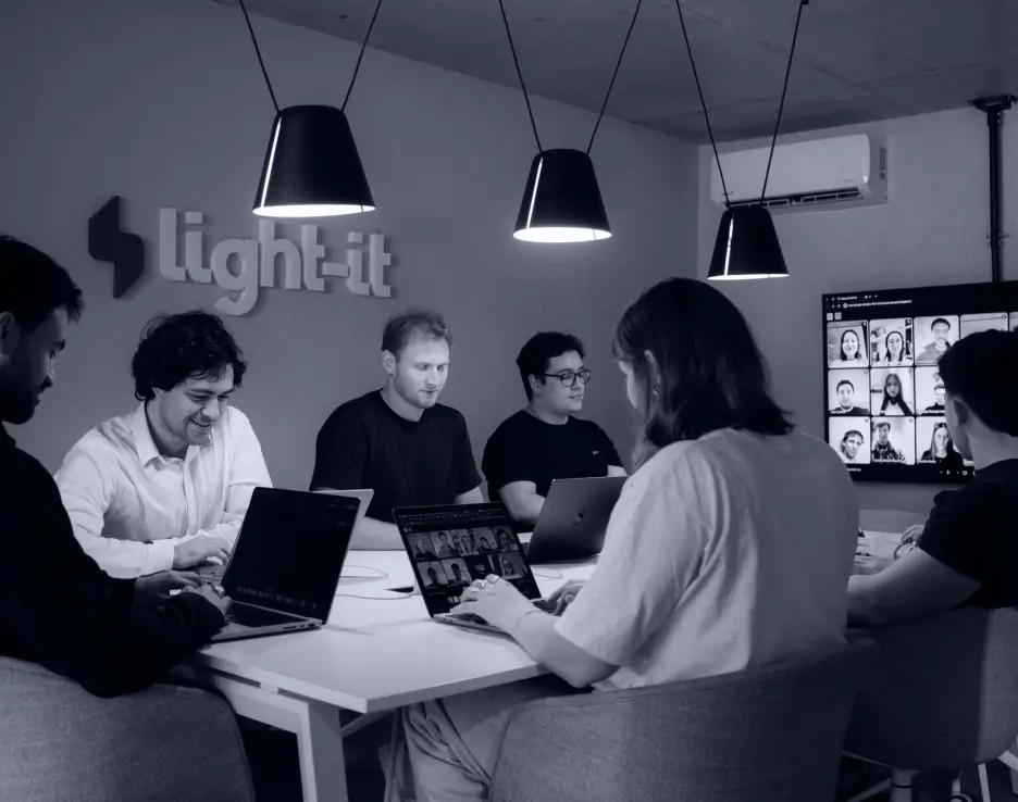 A team of coworkers bonding and laughing in the living room of Light-it's office
