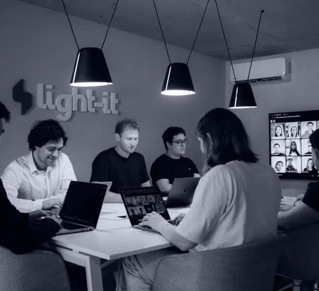 A front-end web developer listening to her colleague in a meeting.