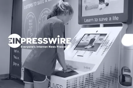 Person practicing hands-only CPR at the OpenCPR training kiosk, with the EIN Presswire logo