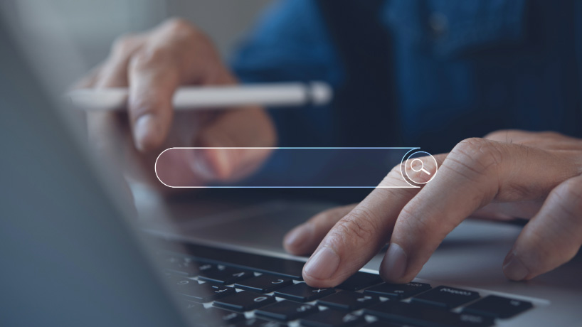 Image of a person using a laptop with a search bar element overlay 