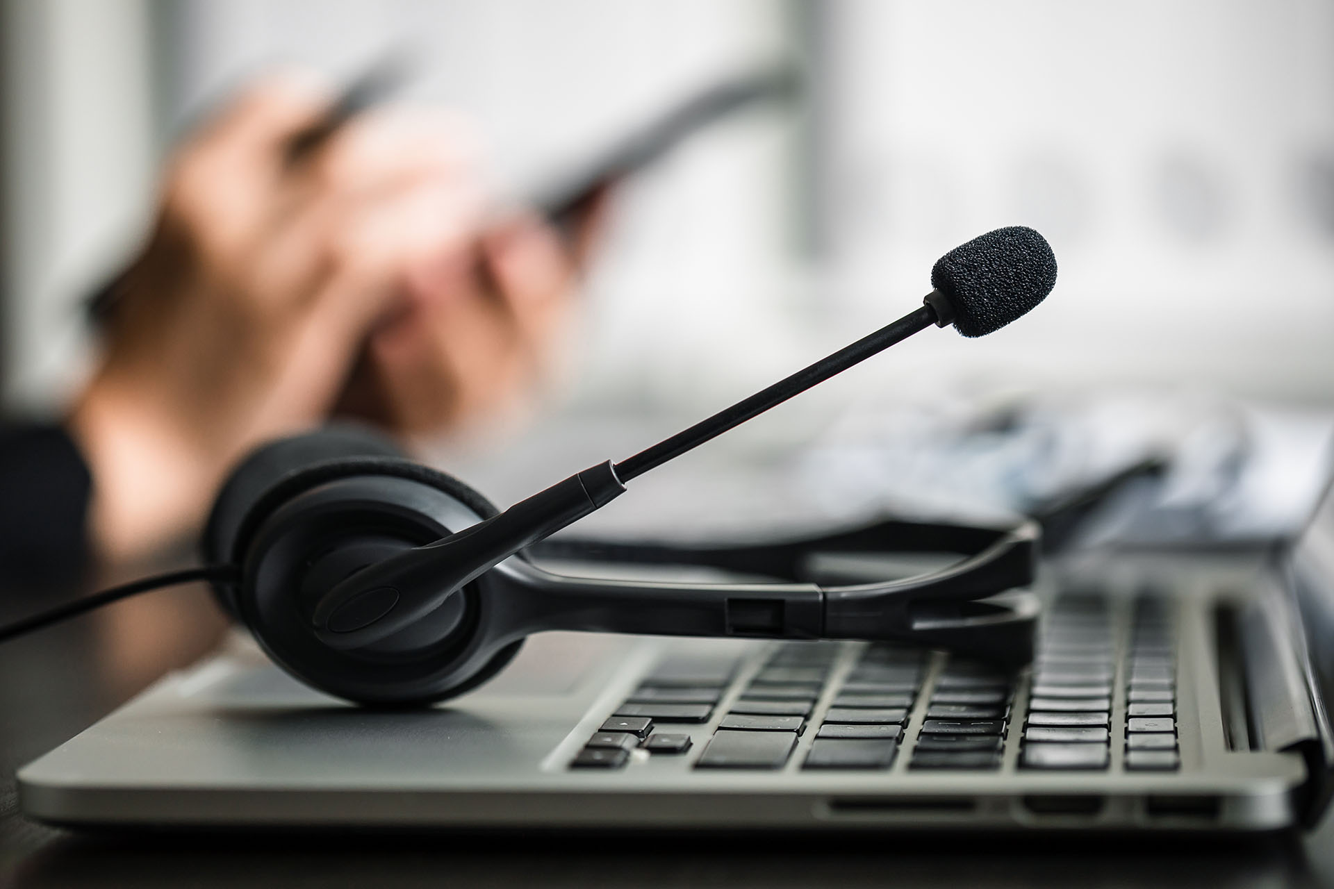 Telemarketing headphones resting on a laptop.