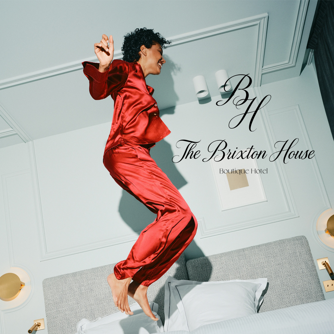 Image of a girl in red slik pj jumping on the bed with the The Brixton House Logo and Icon