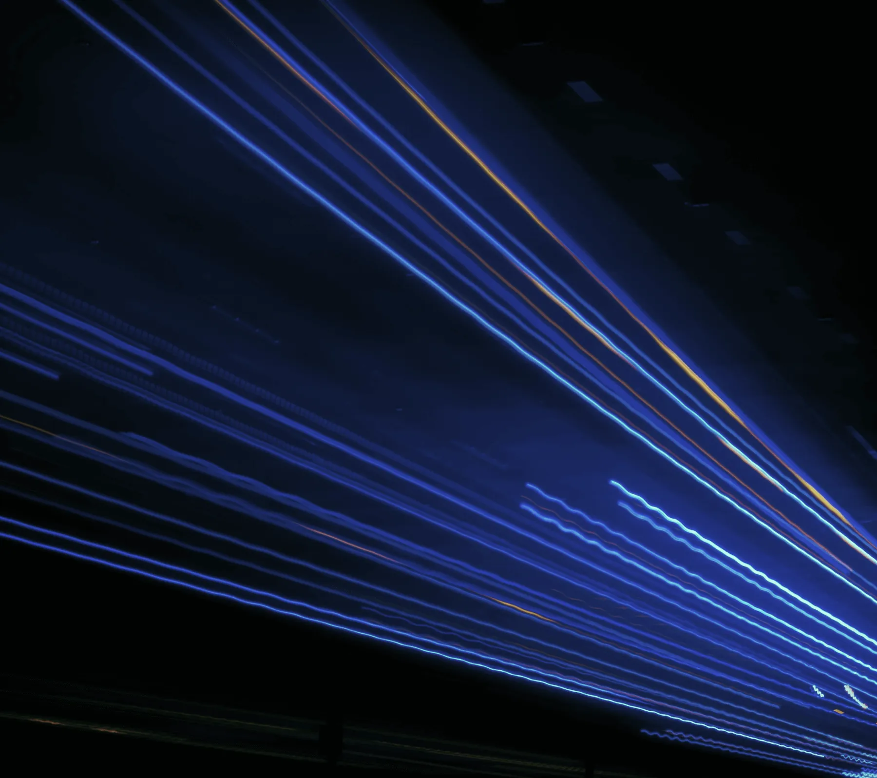 A large burst of colors ranging from blue to pink move in waves across a black background.