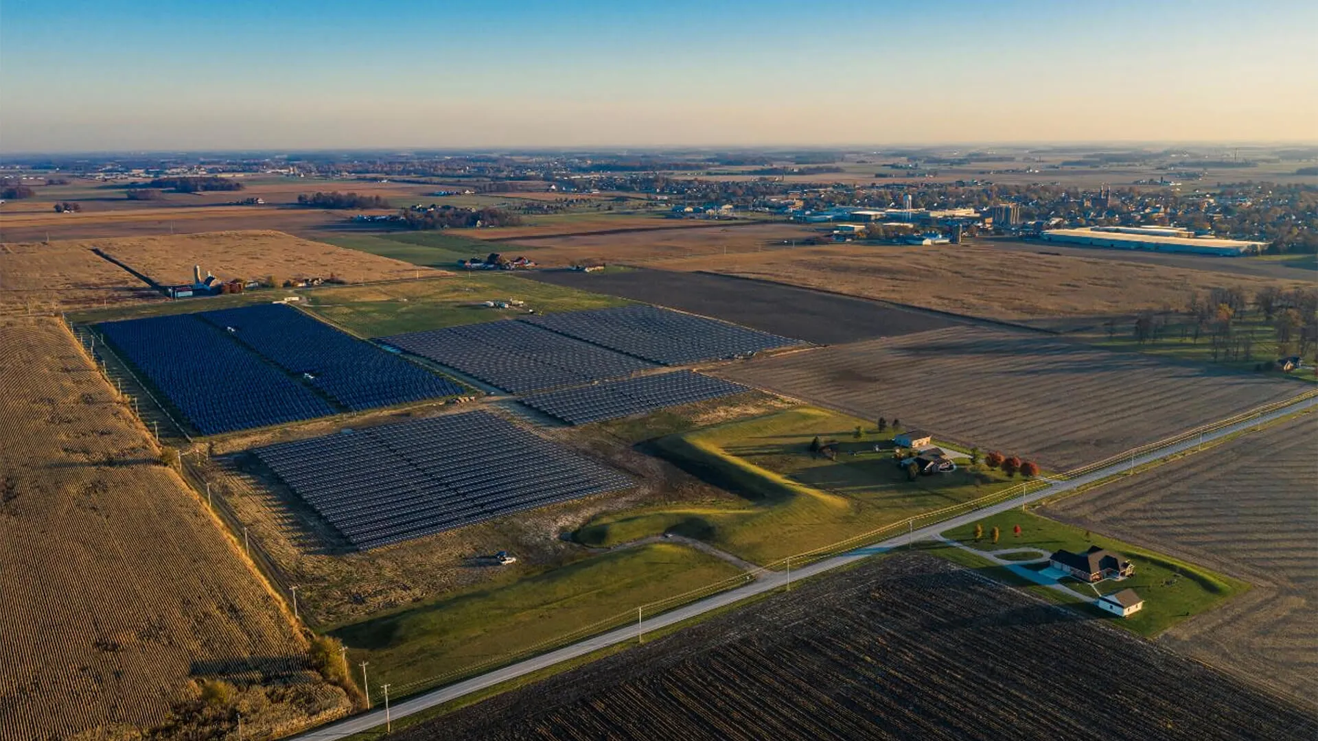 A large field of solar panels reflect the sun in this image taken from above.