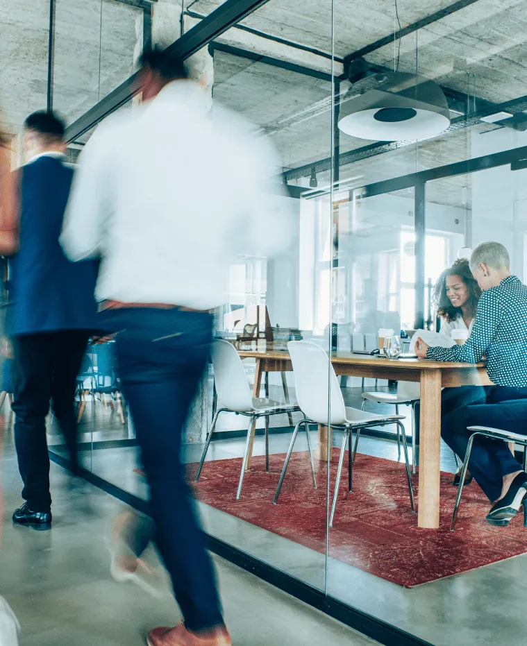 Employees go about their day in a modern office building with glass walls.