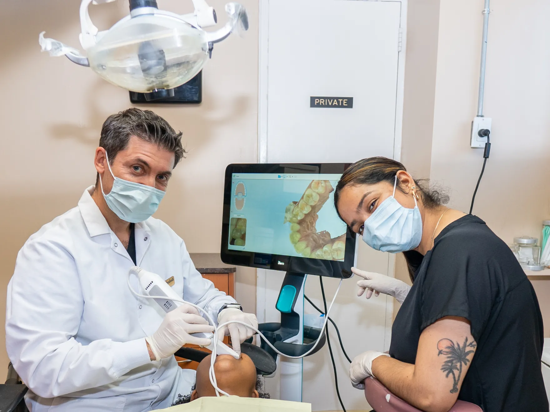 Dr. Khodosh and team member performing a dental checkup on a patient.