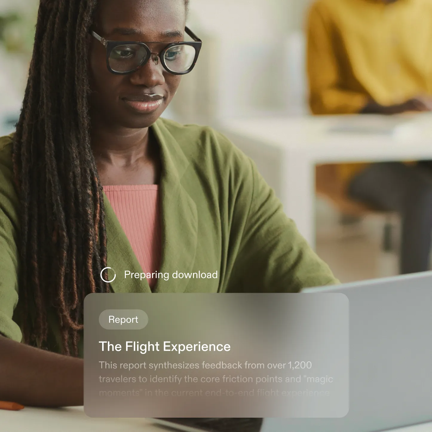Woman with glasses and long braided hair working on a laptop with a report titled 'The Flight Experience' displayed.