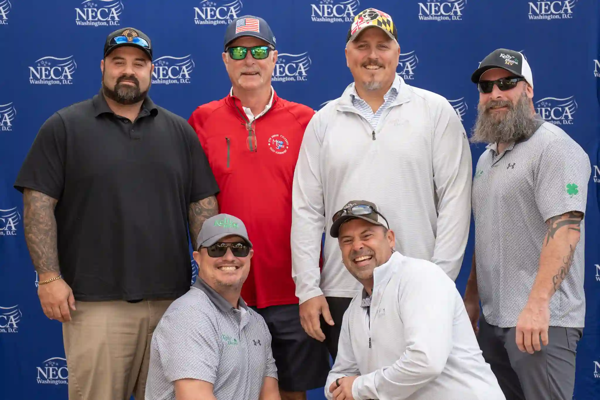 6 male golfers posing in front of NECA step and repeat banner