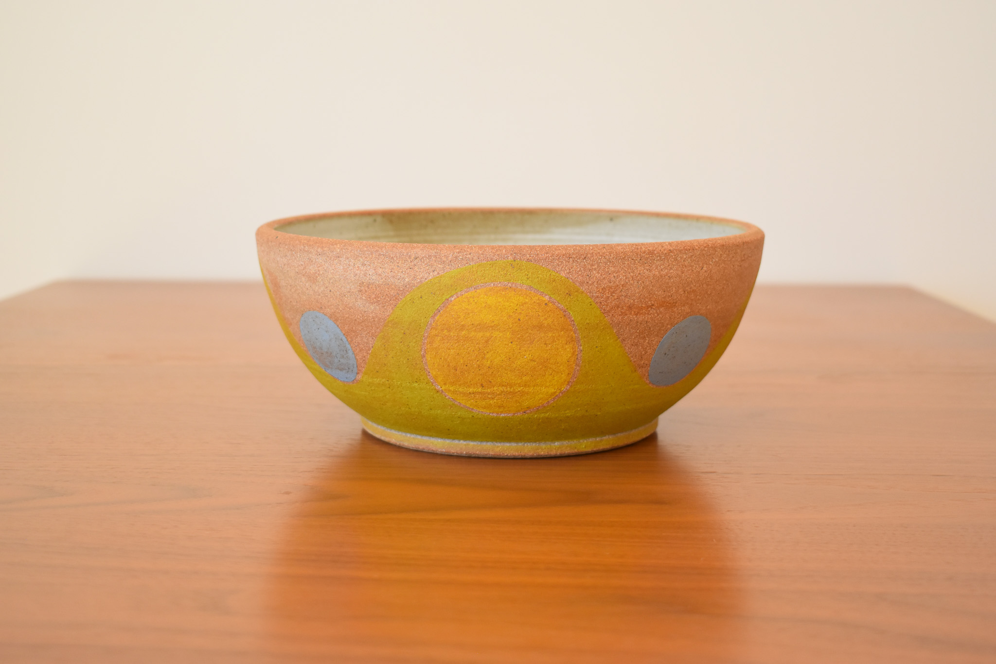 Wheelthrown with stoneware and hand painted using non-toxic underglazes and a white matte glaze. Measures 9.75" wide x 4" tall.