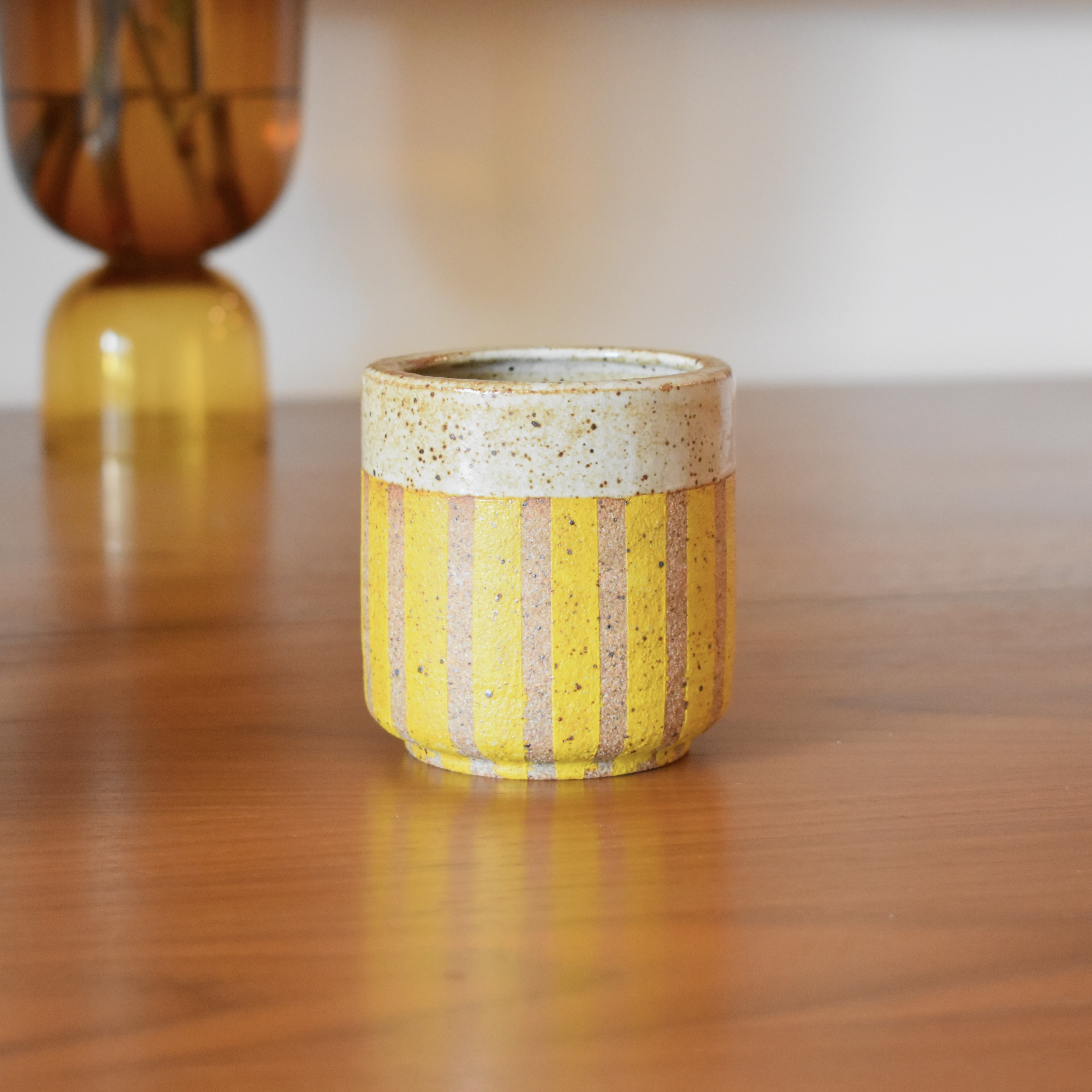 Wheelthrown with stoneware. Glazed in a glossy white with some brown speckling present. Exterior painted with non-toxic underglaze. Hold approximately 8 fl. oz.