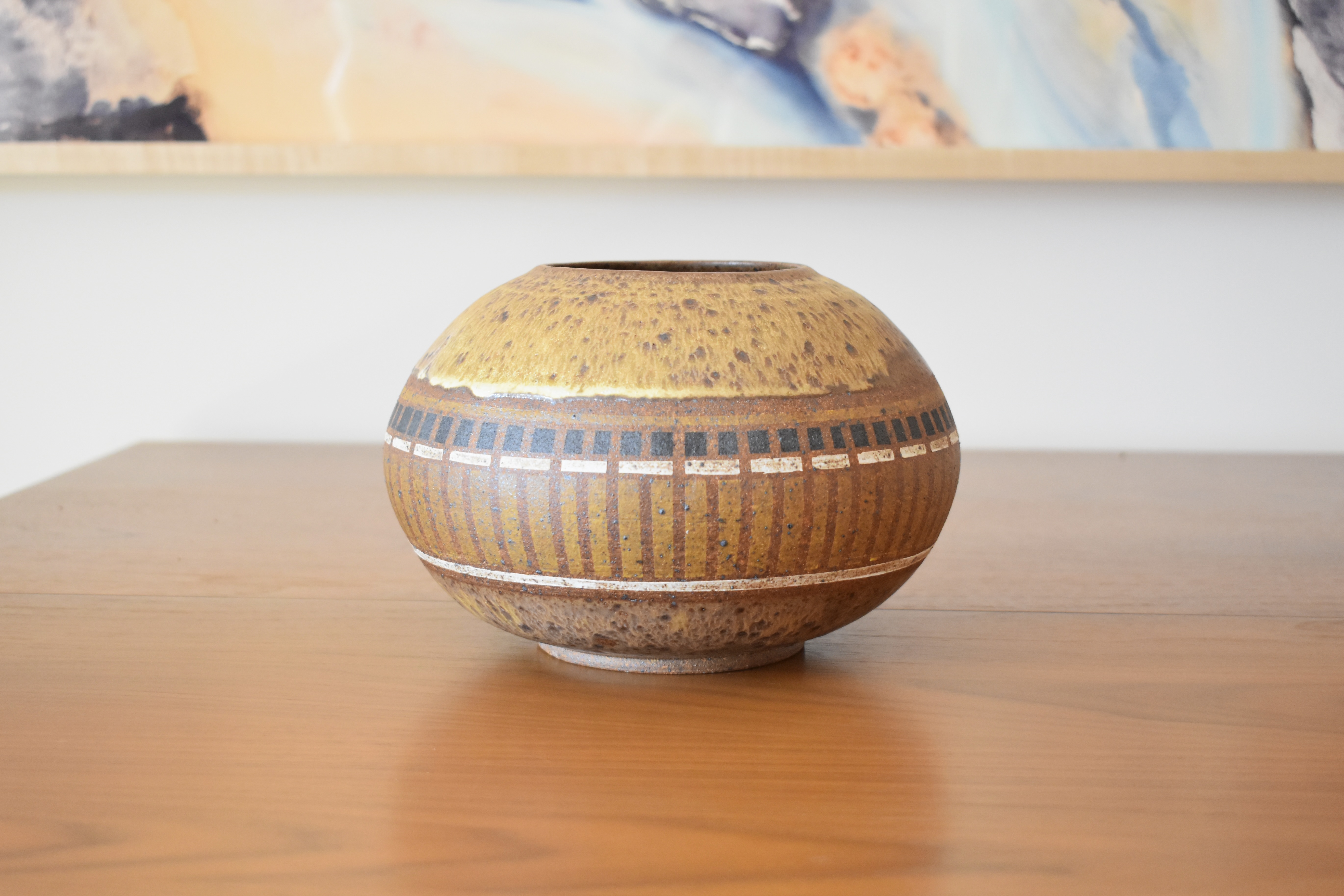 Wheelthrown with stoneware and handpainted with non-toxic underglazes. Exterior and interior glazed in a matte, heavily freckled off white glaze. 5.5" tall, 8" wide and 3.75" wide opening. 