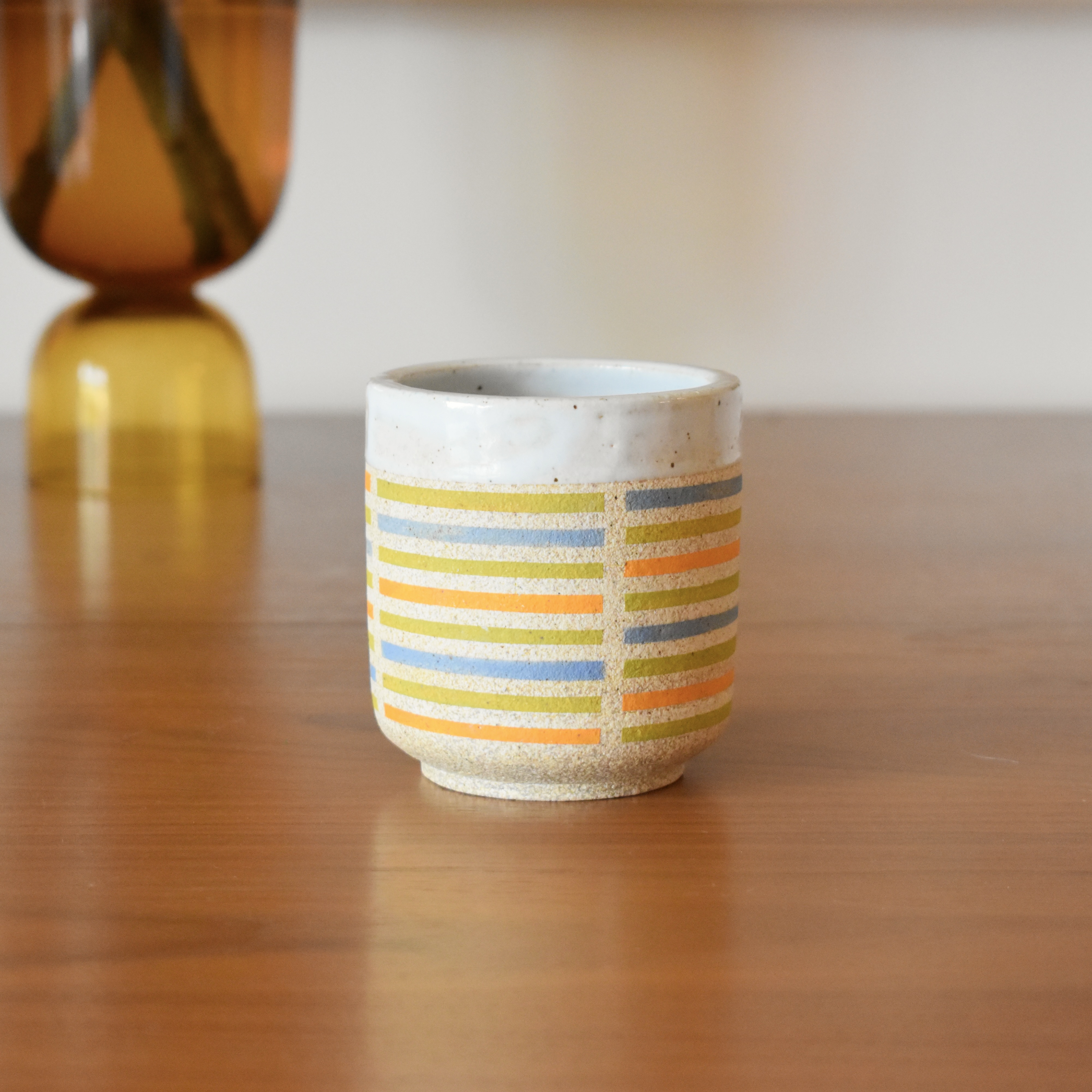 Wheelthrown with stoneware and hand painted using non-toxic underglazes. Glazed glossy white on the interior, and outer lip. 3.25" wide x 3.5" tall. Holds ~10 fl. oz.
