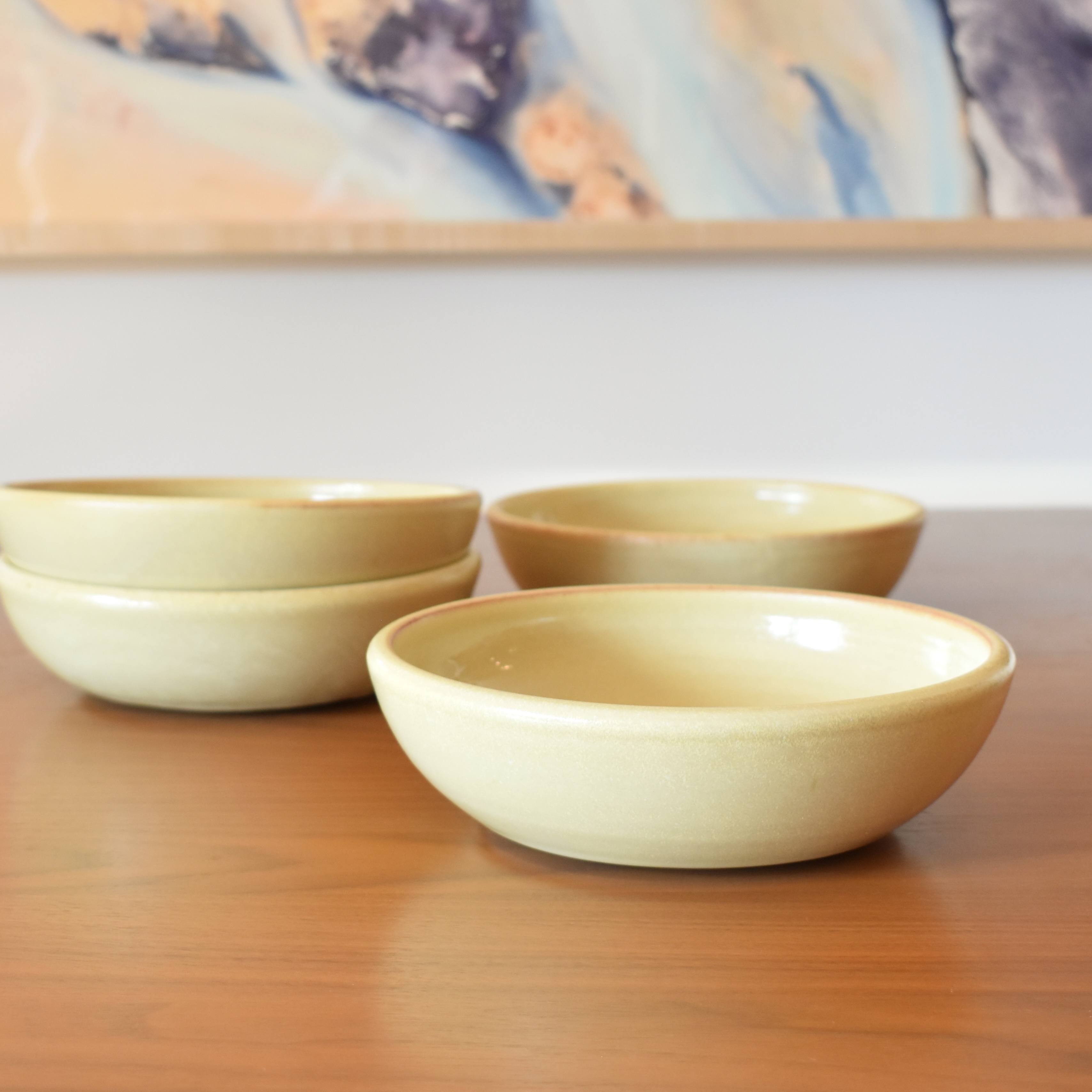 Wheelthrown with stoneware. Glazed in a pale yellow glossy glaze. Measure ~8" wide and 2.25" tall. Sold as a set of 4. Please allow for slight variation in glaze and size as each piece is handmade. 