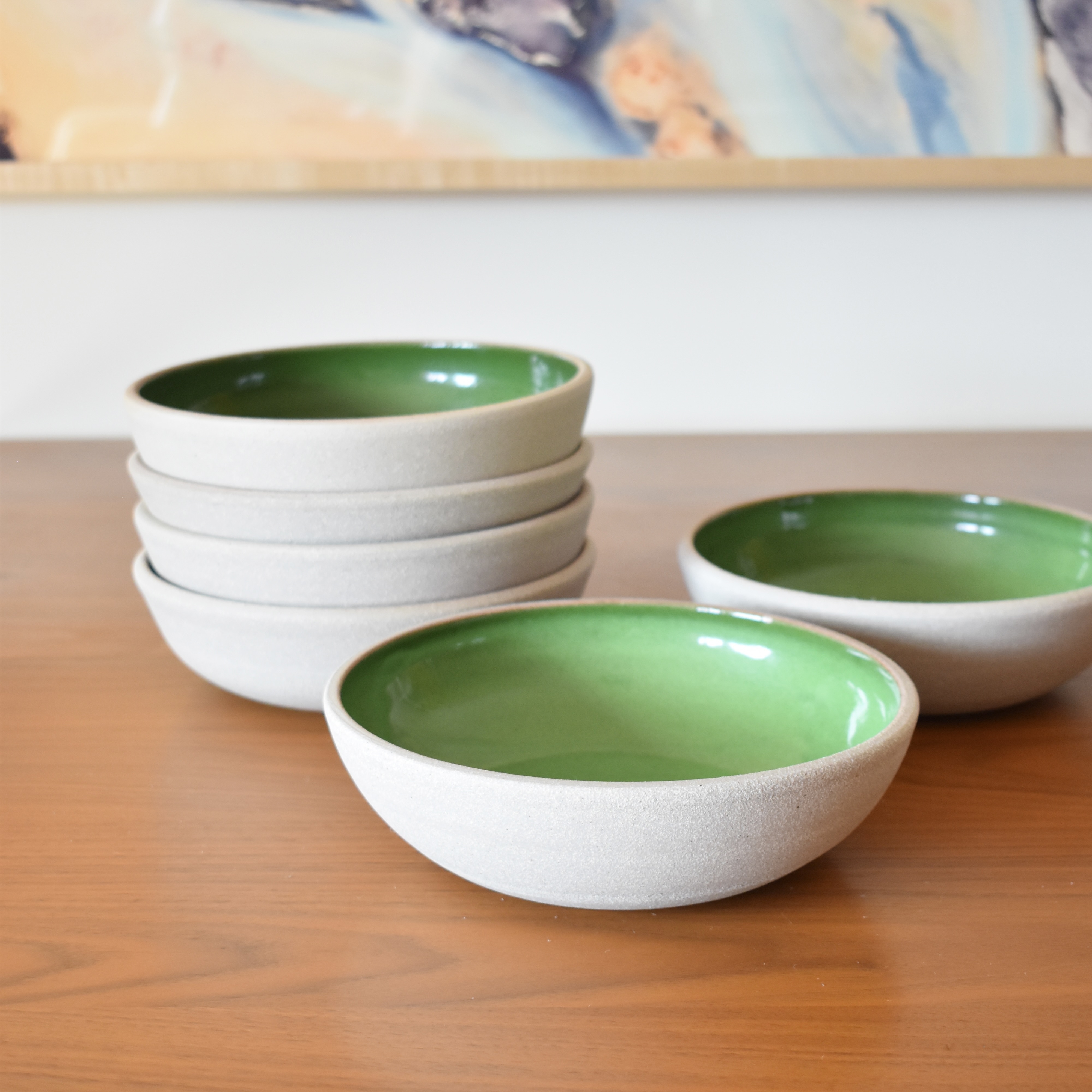 Wheelthrown with stoneware. Interior is glazed in a bright glossy green. Exterior and rim unglazed. Measure 8" wide x 2.25" tall. Sold as a set of 6. Please allow for slight variation in glaze and size as each piece is handmade. 