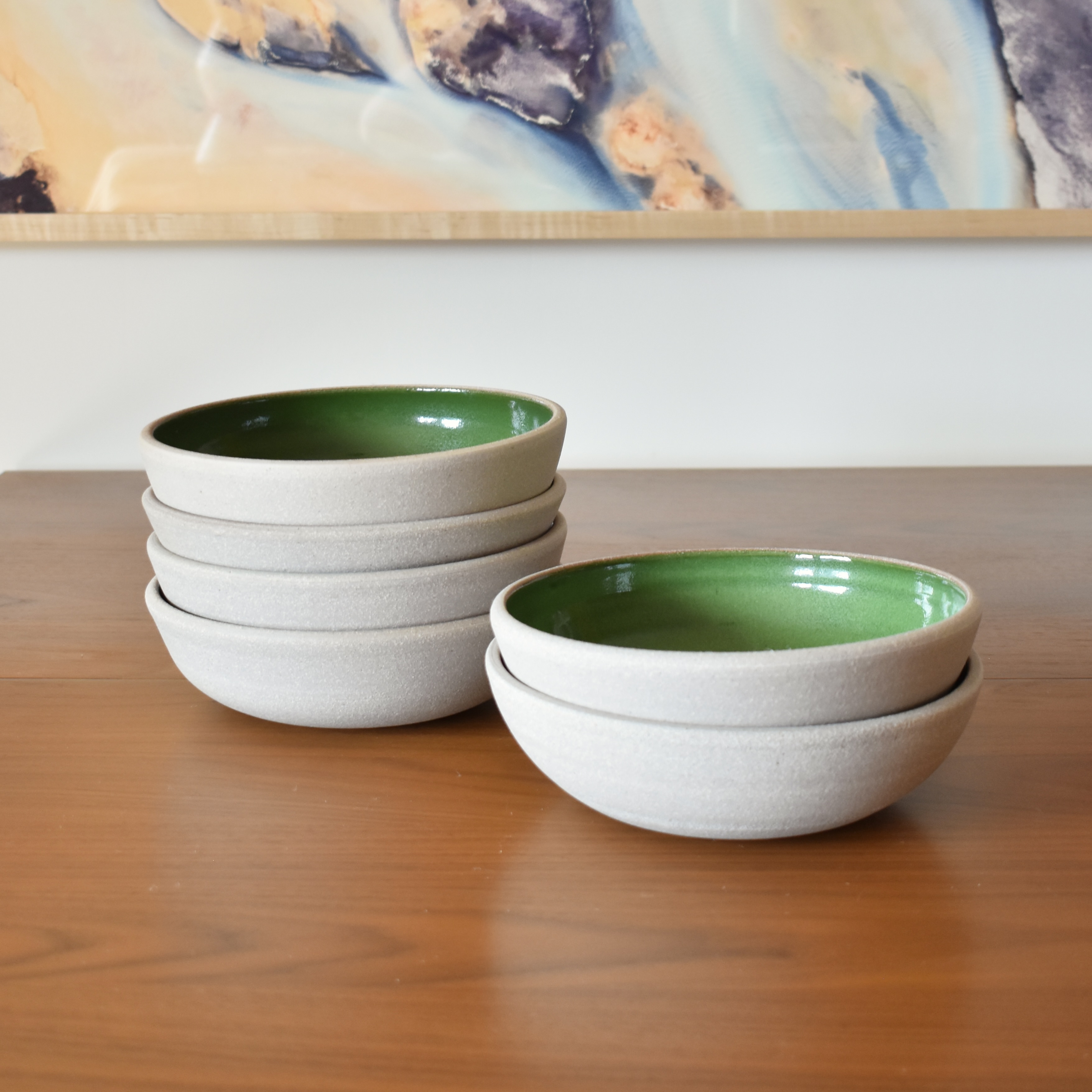 Wheelthrown with stoneware. Interior is glazed in a bright glossy green. Exterior and rim unglazed. Measure 8" wide x 2.25" tall. Sold as a set of 6. Please allow for slight variation in glaze and size as each piece is handmade. 