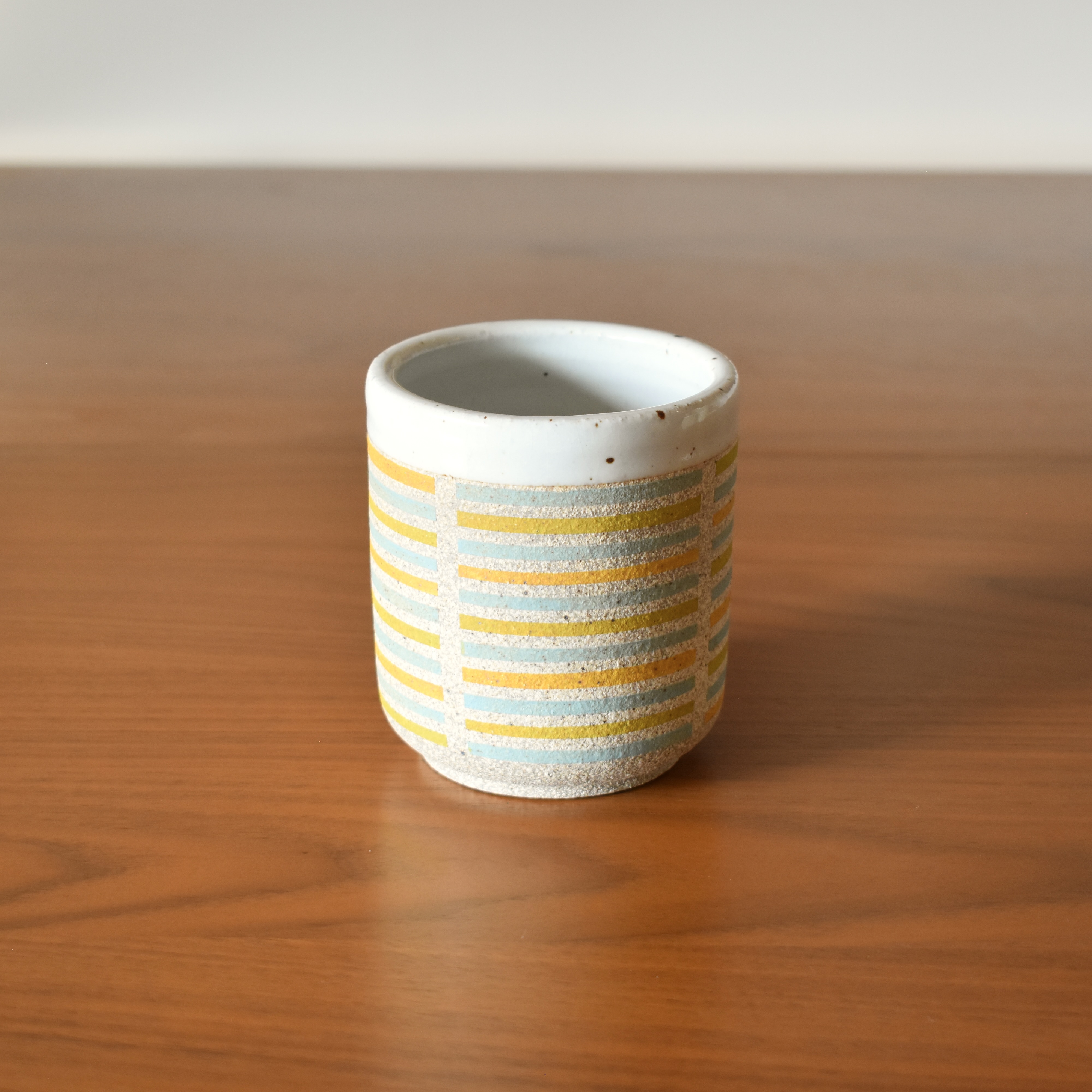 Wheelthrown with stoneware and hand painted using non-toxic underglazed. Glazed glossy white on the interior and outer lip. 3.5" wide x 3.75" tall. Holds ~10fl. oz.