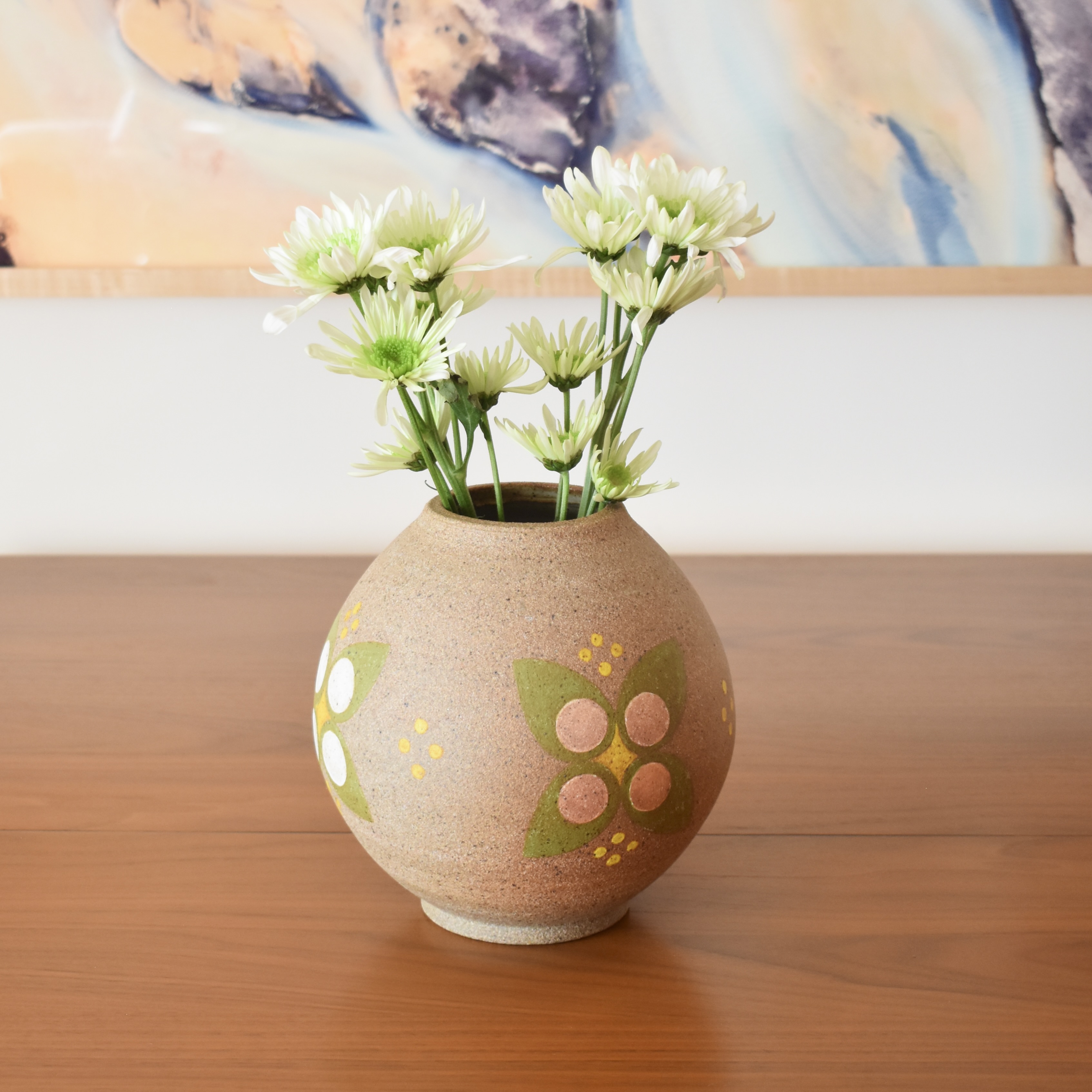 Wheelthrown with stoneware and handpainted with non-toxic underglazes. Interior glazed in a glossy, heavily freckled white glaze. Measures 7" tall. 