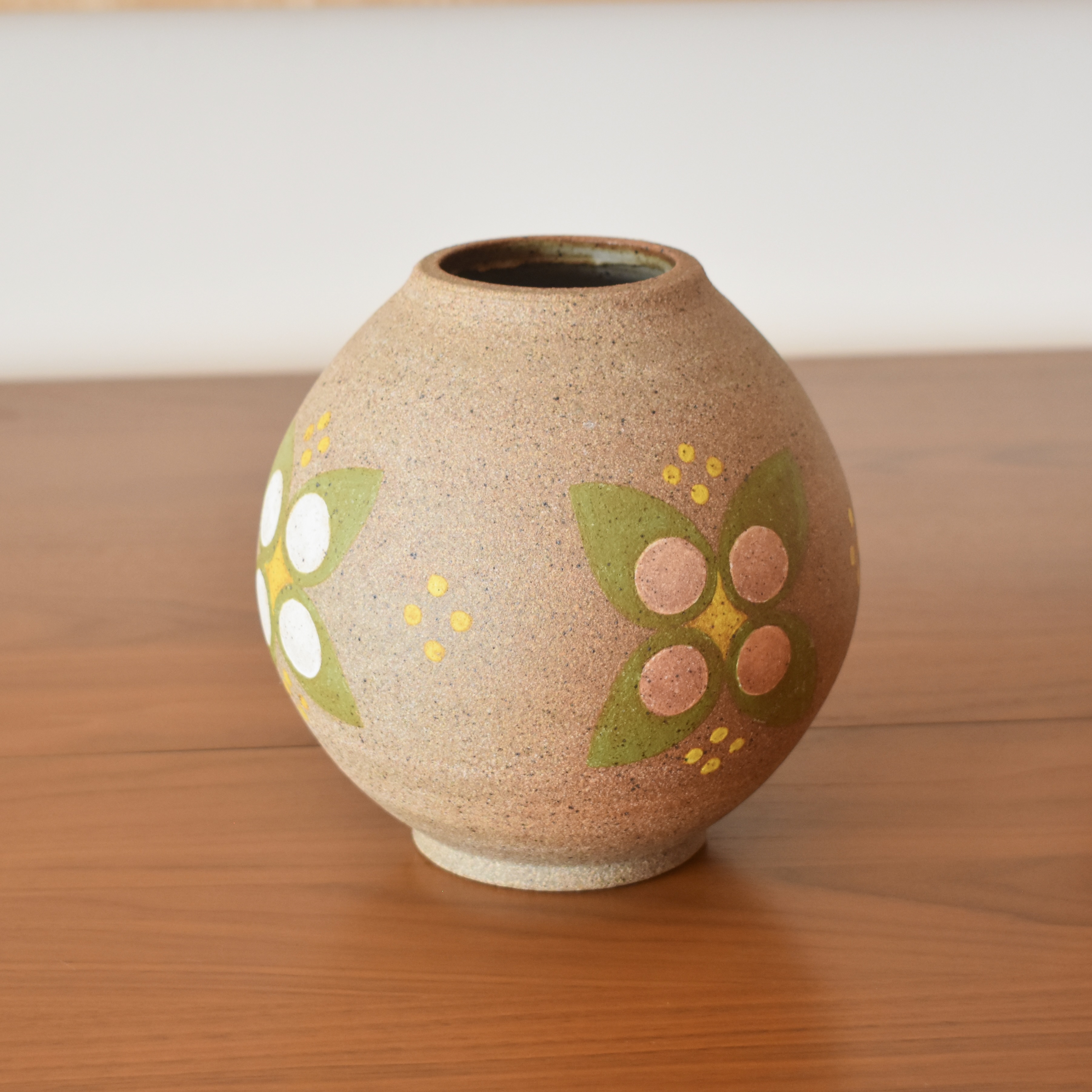 Wheelthrown with stoneware and handpainted with non-toxic underglazes. Interior glazed in a glossy, heavily freckled white glaze. Measures 7" tall. 