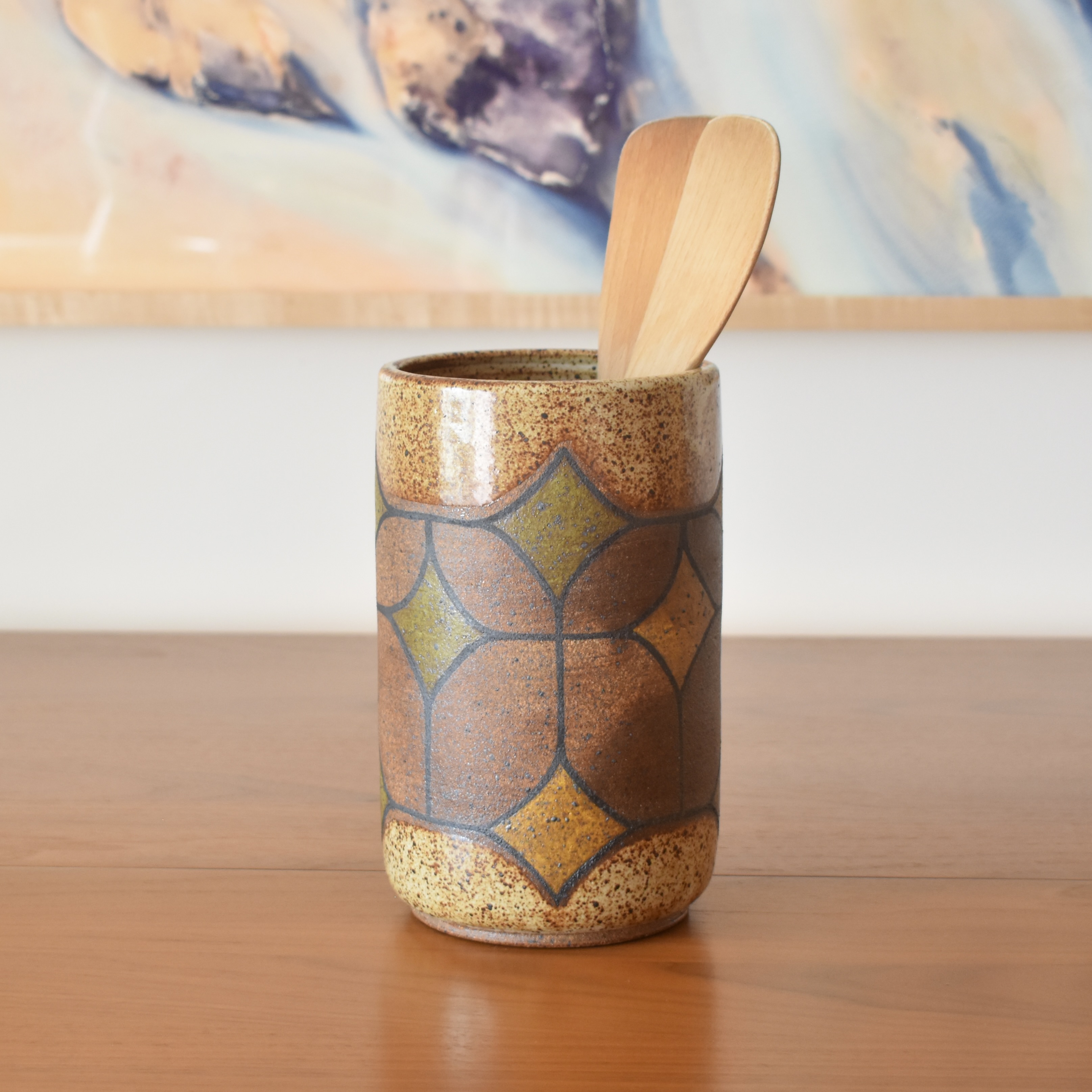 Wheelthrown with stoneware and painted with non-toxic underglazes. Outer lip and interior glazed in a heavily freckled glossy white/brown glaze. 8" tall x 5" wide.