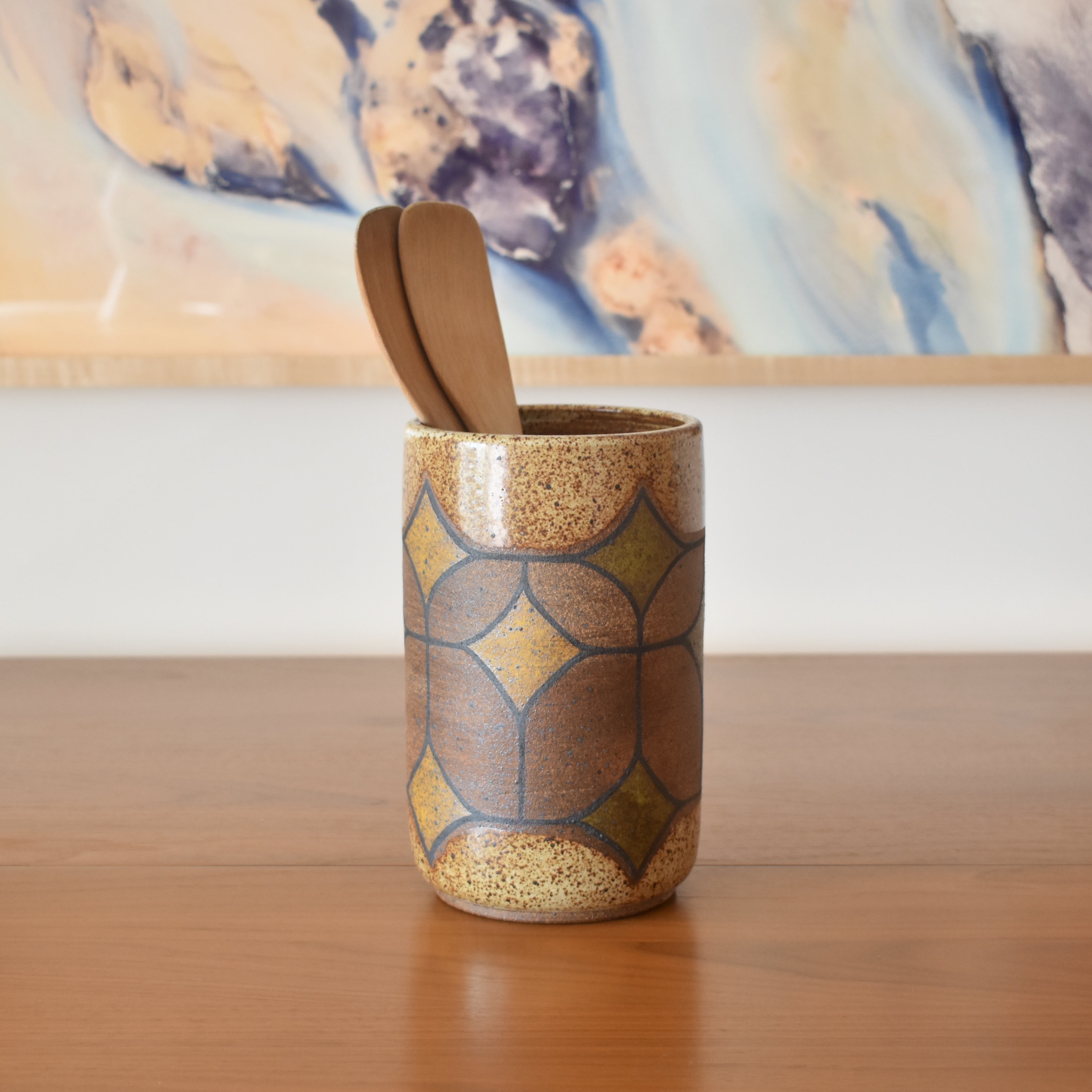 Wheelthrown with stoneware and painted with non-toxic underglazes. Outer lip and interior glazed in a heavily freckled glossy white/brown glaze. 8" tall x 5" wide.