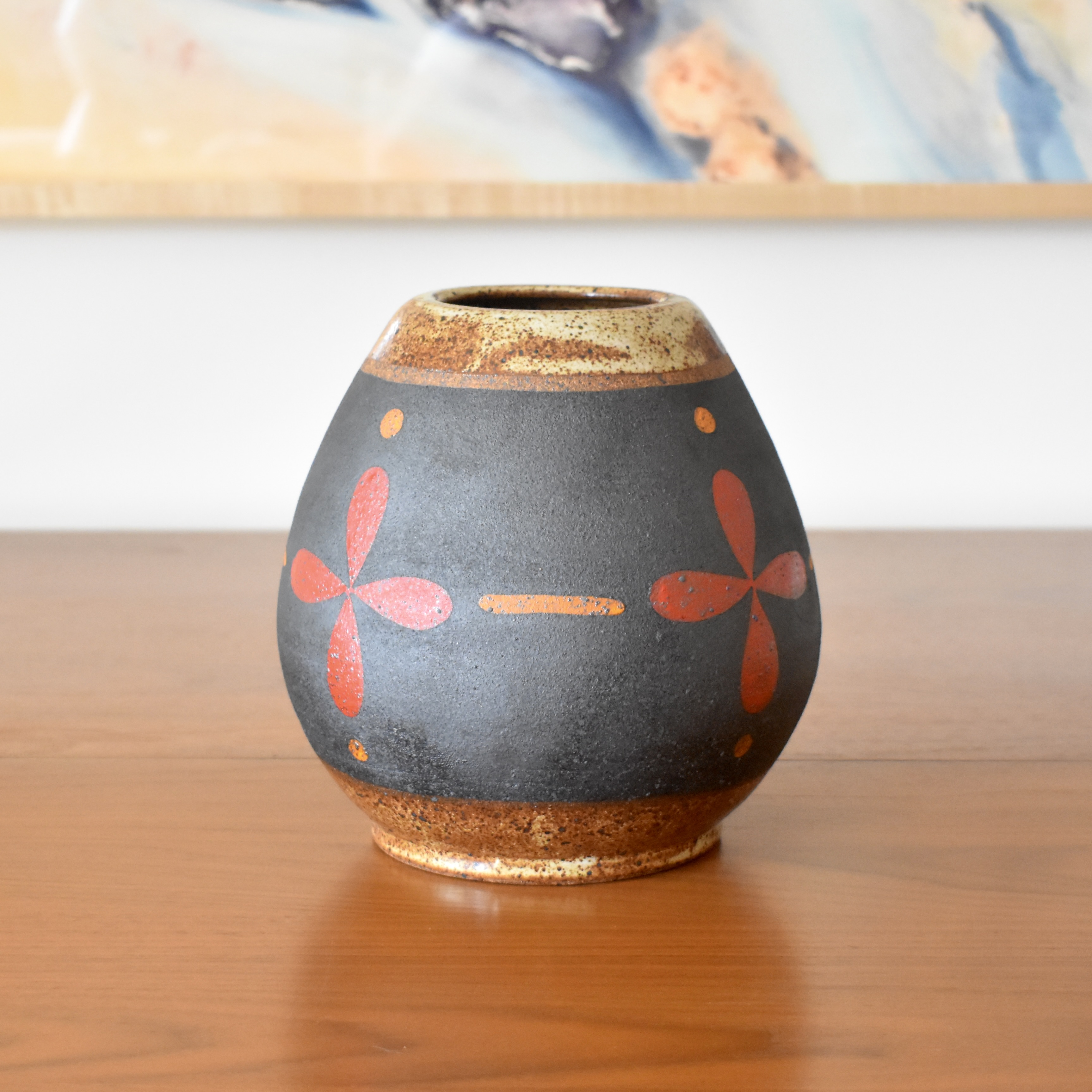 Wheelthrown with stoneware and painted with non-toxic underglazes. Outer lip and interior glazed in a heavily freckled glossy white/brown glaze. 7.5" tall, 3" opening, and overall width of 6.5". 
