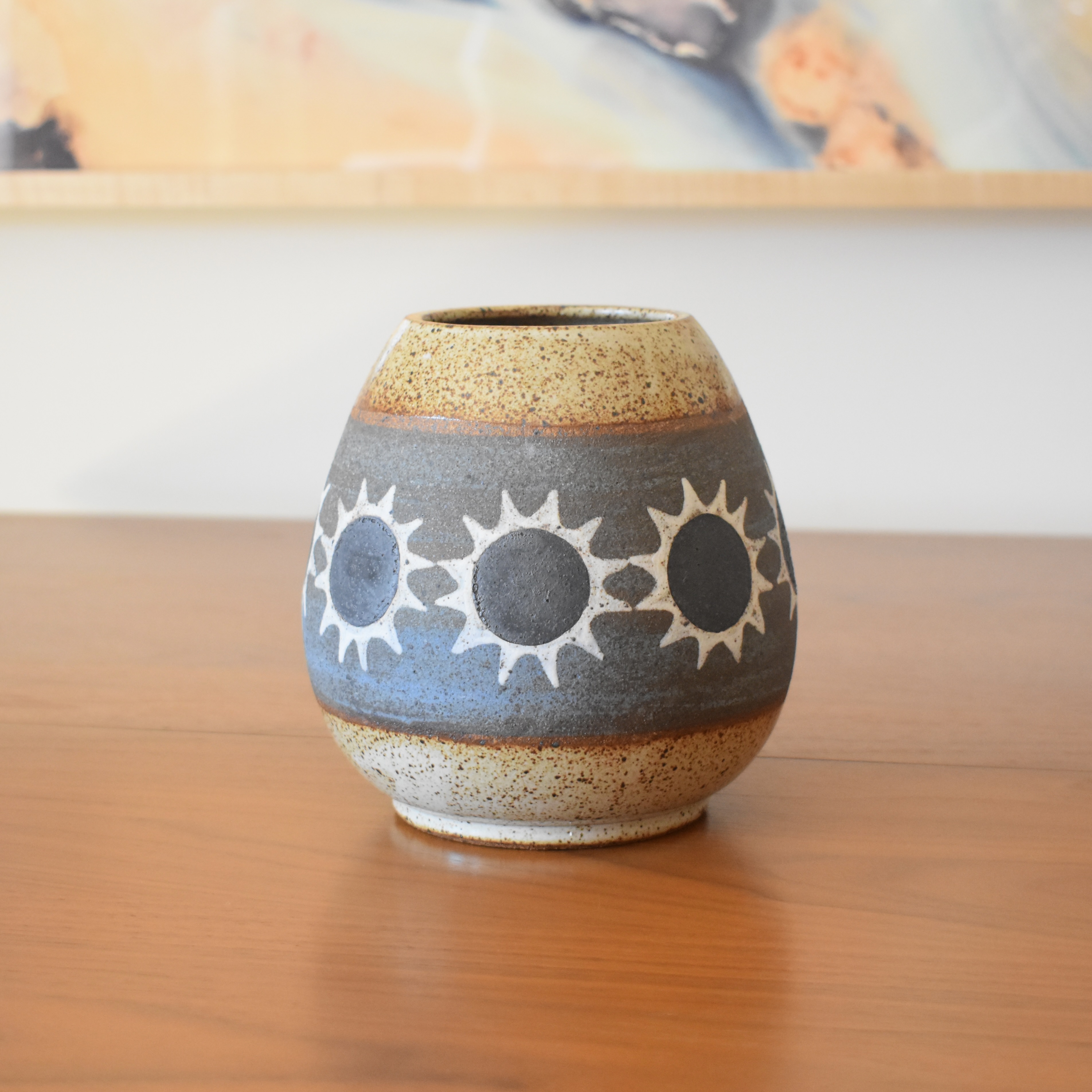 Wheelthrown with stoneware and painted with non-toxic underglazes. Glazed in a heavily freckled glossy whiteglaze. 6.2.5" tall, 3" opening, and overall width of 5.5". 