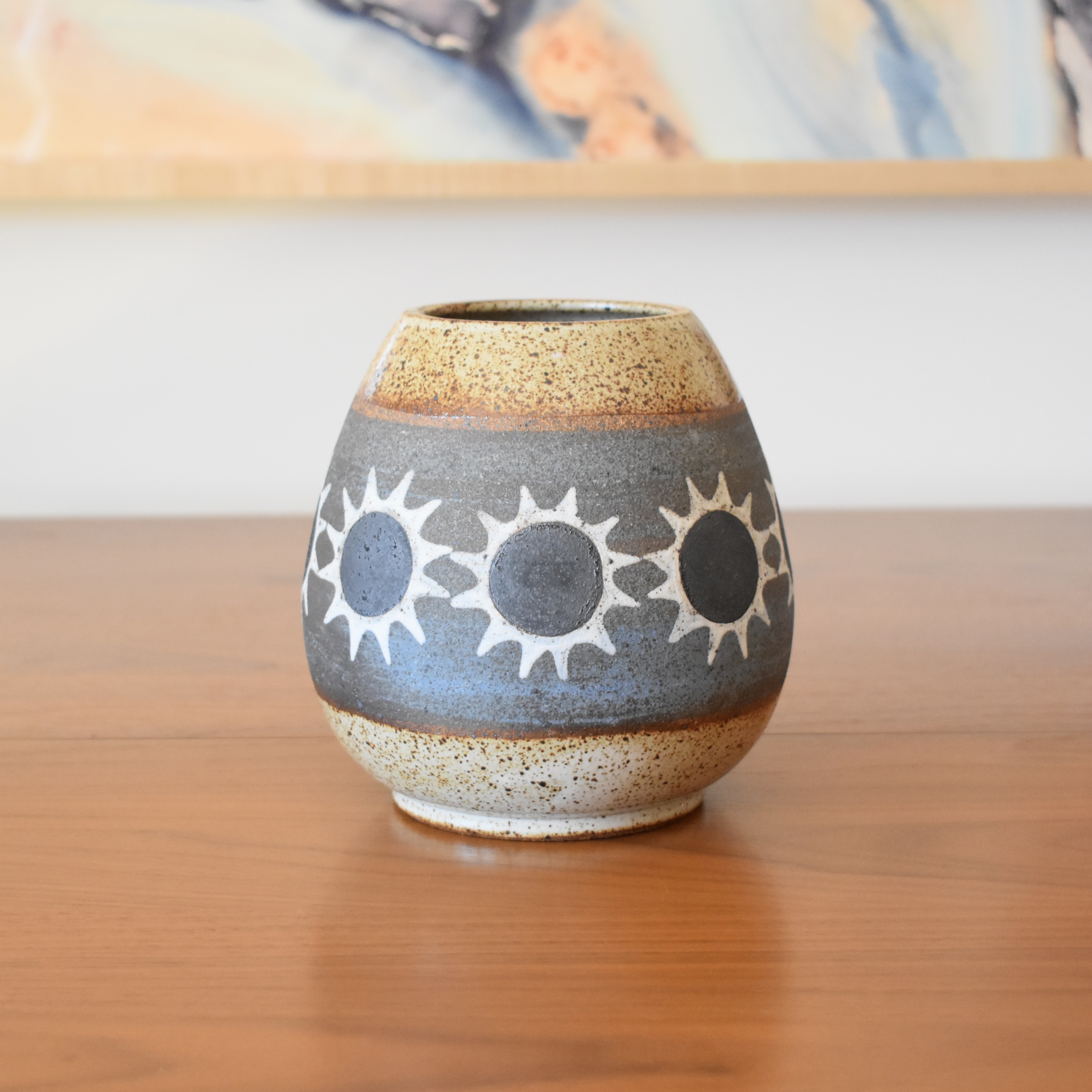 Wheelthrown with stoneware and painted with non-toxic underglazes. Glazed in a heavily freckled glossy whiteglaze. 6.2.5" tall, 3" opening, and overall width of 5.5". 