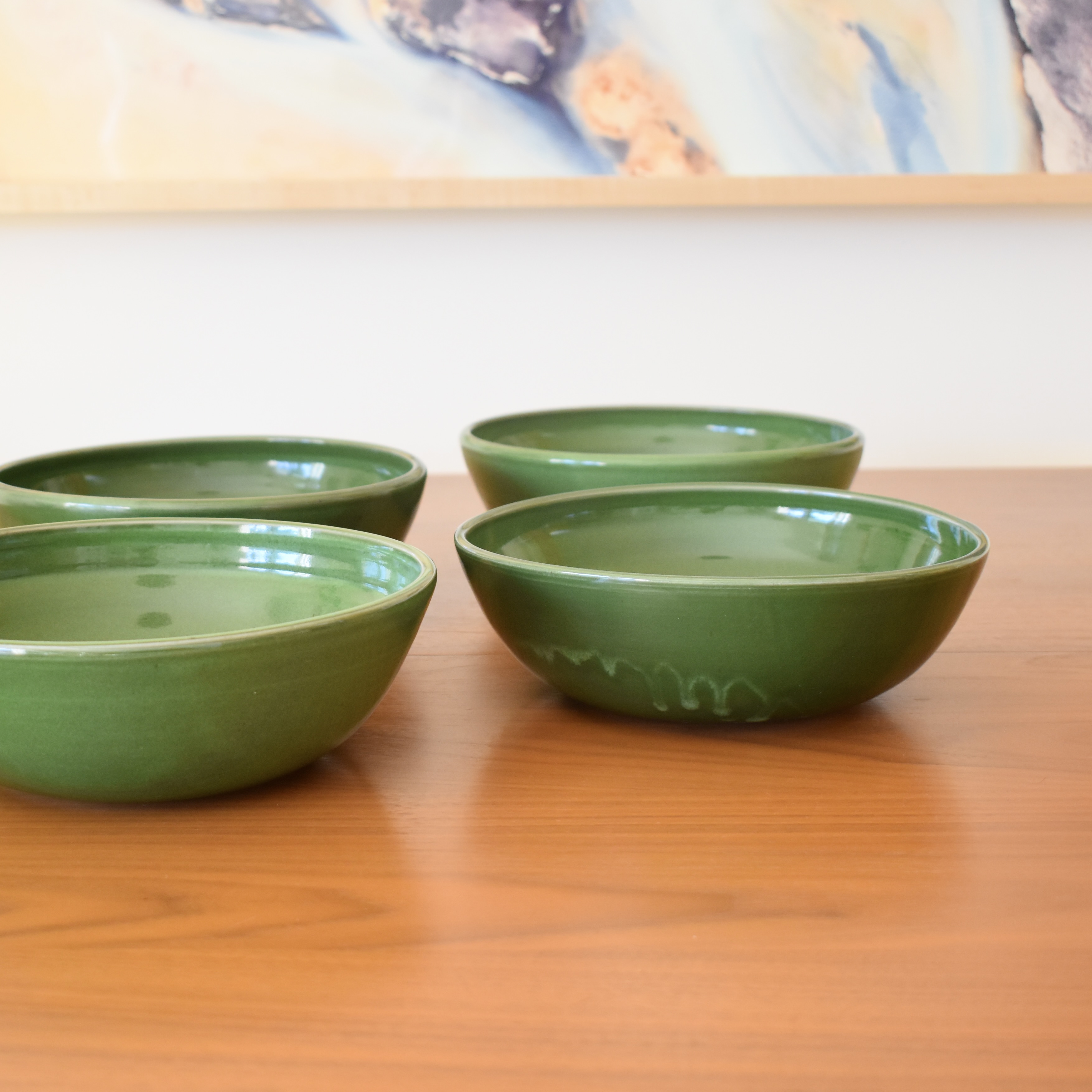 Wheelthrown with stoneware. Glazed in a bright glossy green. Measure 8" wide x 2.75" tall. Sold as a set of 4. Please allow for slight variation in glaze and size as each piece is handmade. 