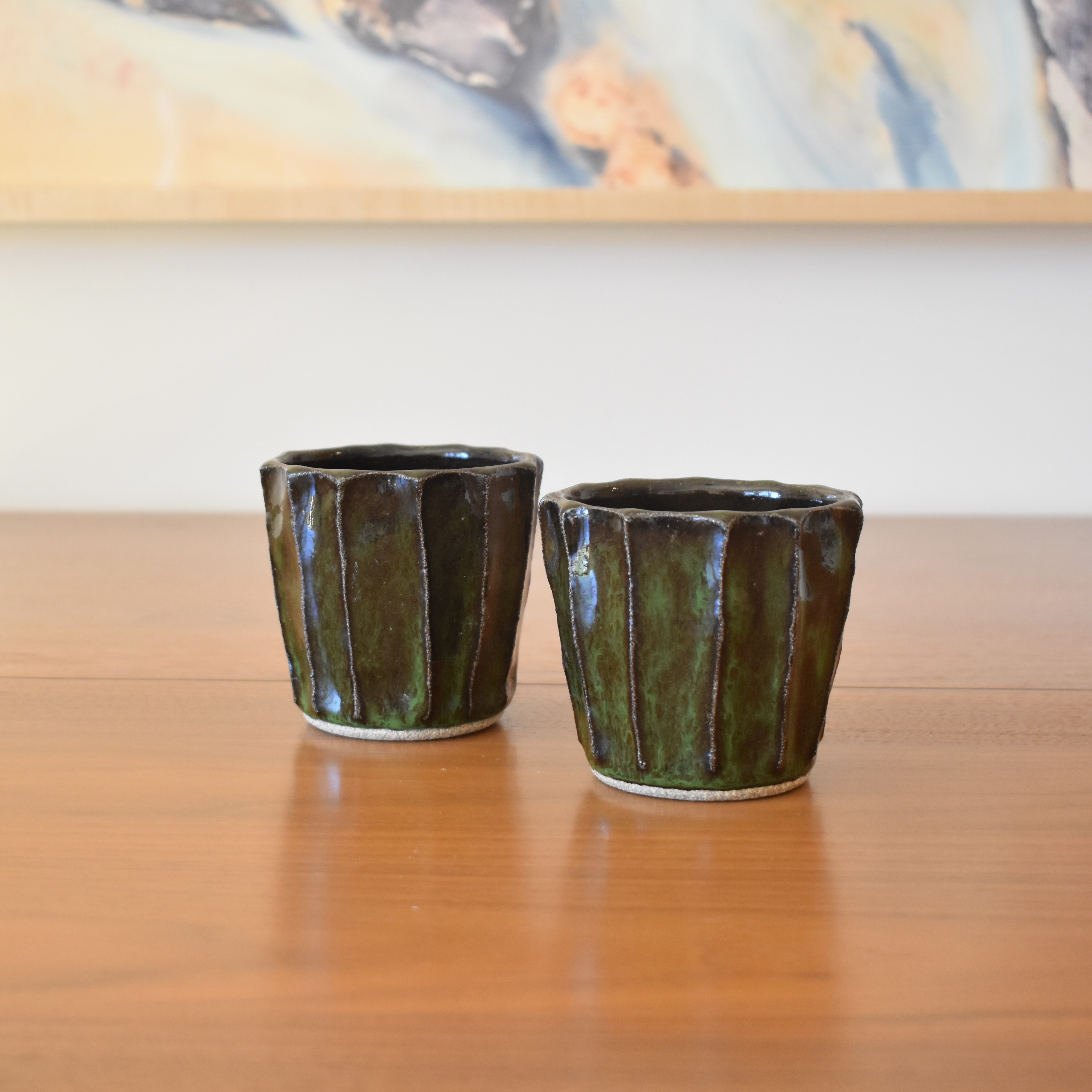 Wheelthrown with stoneware and then hand carved for a faceted look. Glazed in a glossy black / green. 3.5" wide x 3.25" tall. Hold approximately 12 fl oz. 