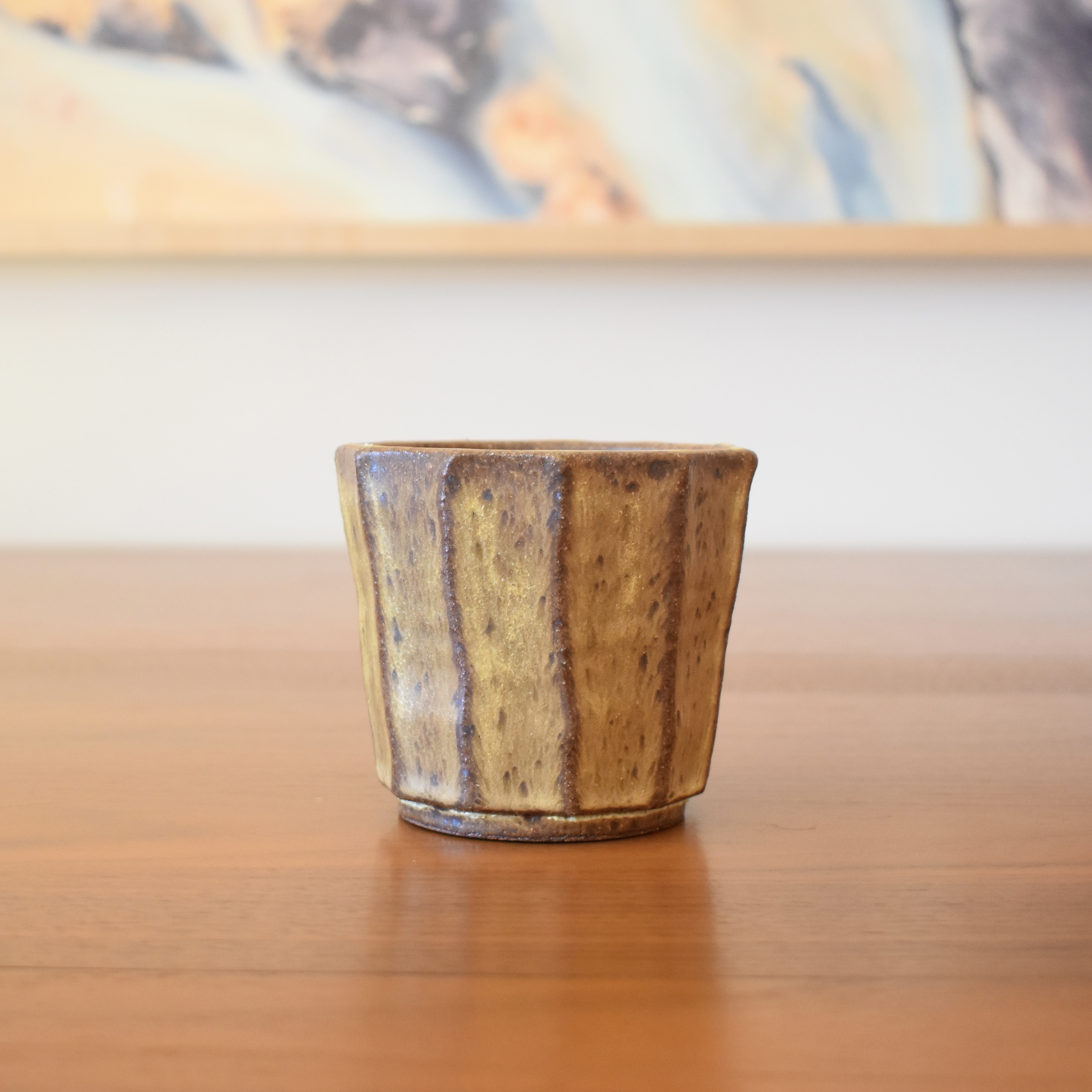 Wheelthrown with stoneware and then hand carved for a faceted look. Glazed in a glossy black / green. 3.5" wide x 3.5" tall. Hold approximately 12 fl oz. 