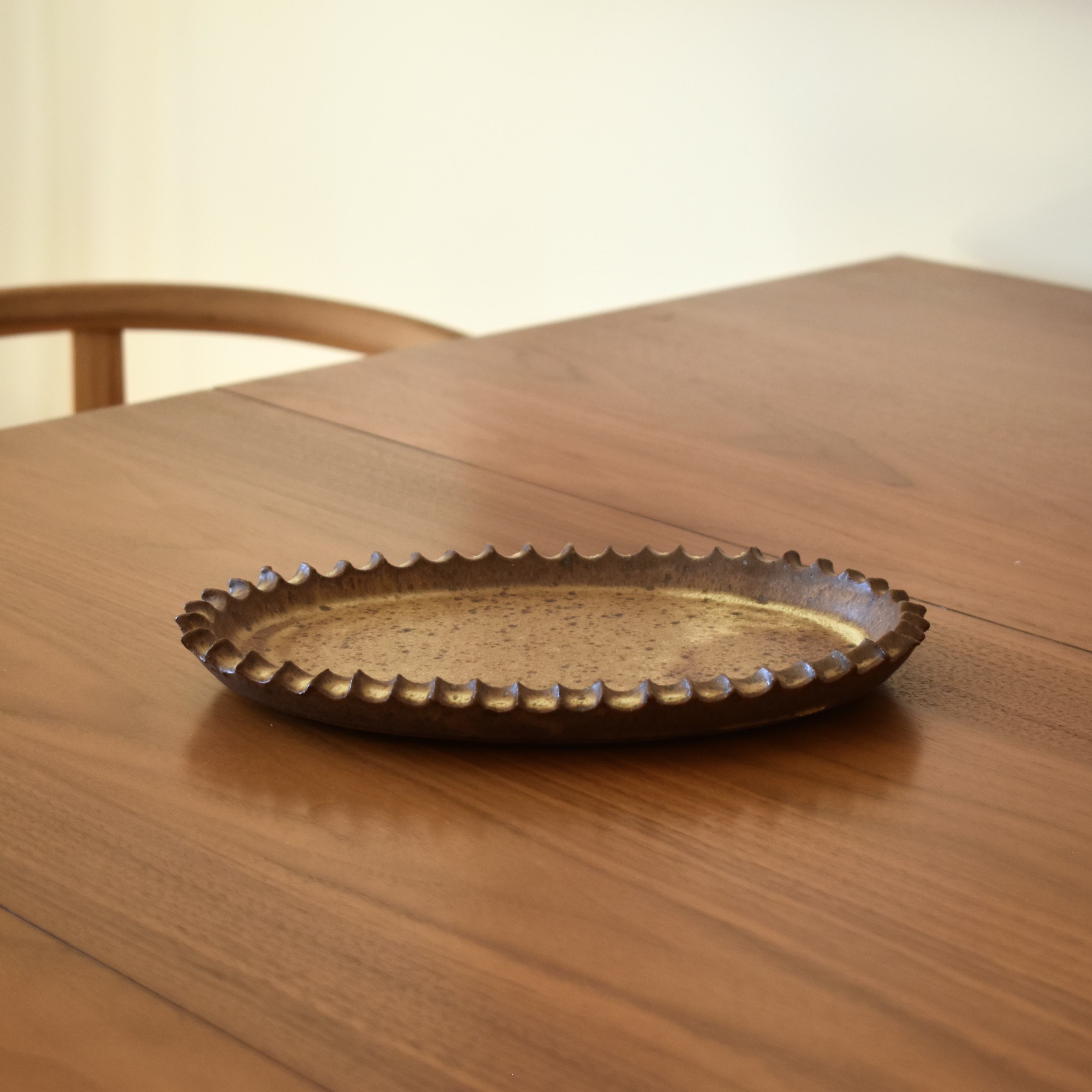 A handbuilt tray. This item is for decorative use only. It is not food safe. Measures 10" long x 7" wide.