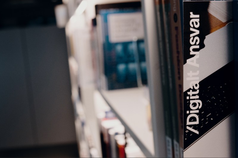 Et bogmærke hvor der er påtrykt "Digitalt Ansvar" står i en bogreol