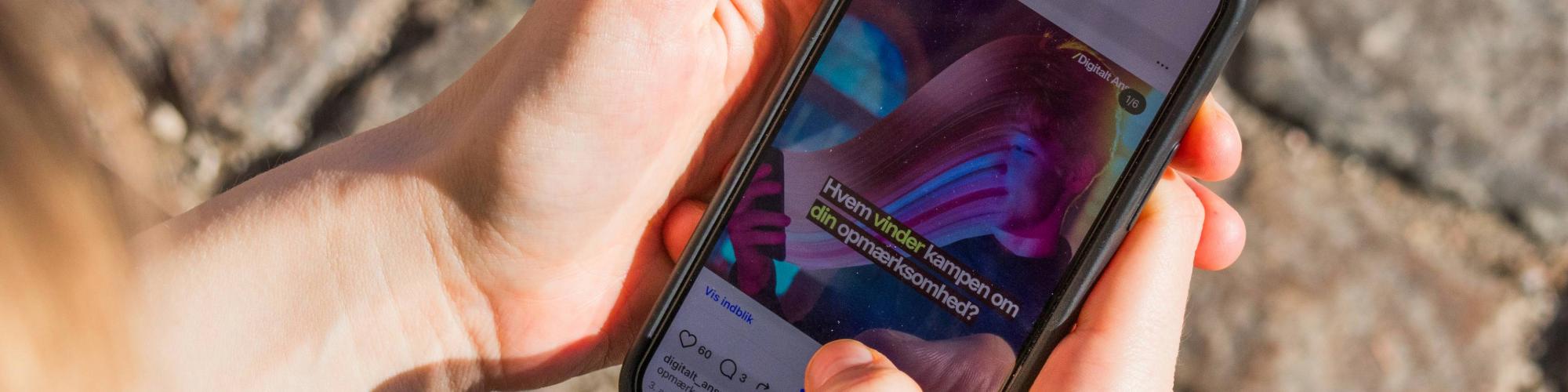 En smartphone med et Instagram opslag fra Digitalt Ansvar