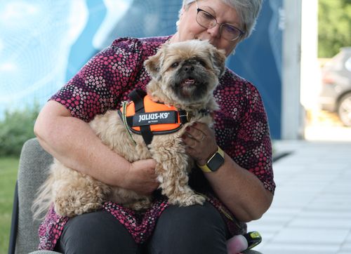 A smiling woman with her dog on bring you dog to work day at the Workiro office