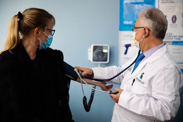 Doctor and patient assess blood pressure. 