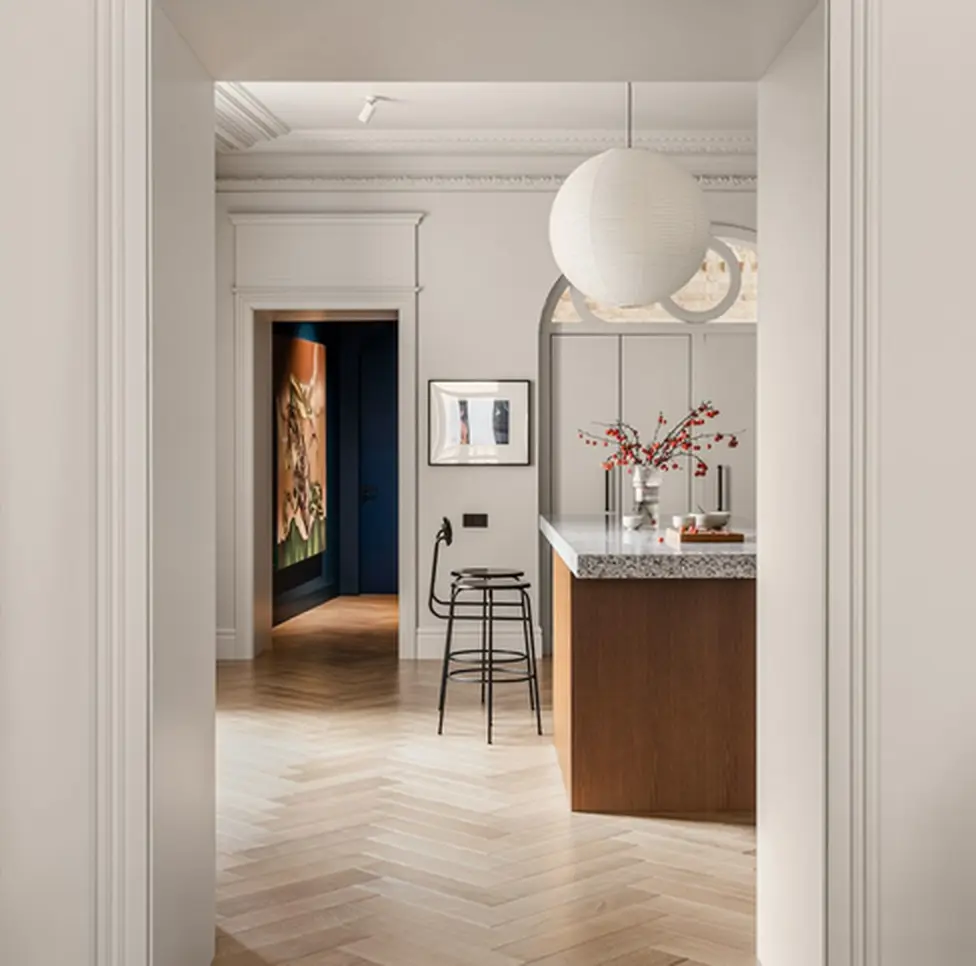 Open-plan London apartment with kitchen island seen through a doorway