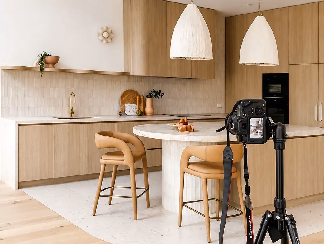 Camera on a tripod photographing a modern short-let kitchen