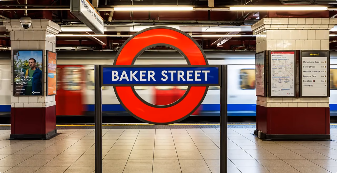 Baker Street Underground roundel on a tiled platform as a tube train passes